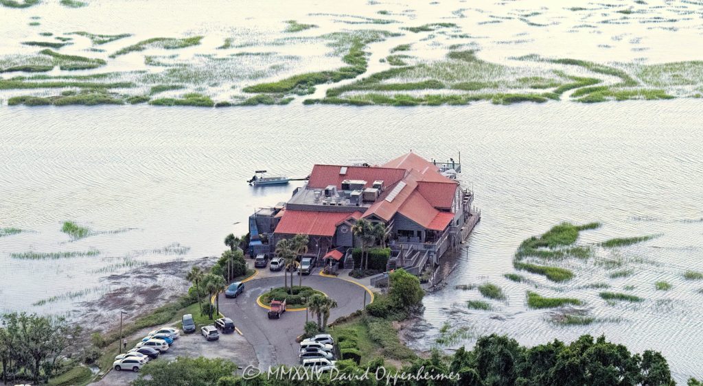 Old Oyster Factory restaurant at 101 Marshland Road on Hilton Head Island, South Carolina, aerial view - © 2024 David Oppenheimer - Performance Impressions photography archives - https://performanceimpressions.com Old Oyster Factory, Old Oyster Factory Restaurant, 101 Marshland Rd, Bram Landing, Broad Creek, creek, marsh, saltmarsh, wetlands, seafood, seafood restaurant, restaurant, oysters, raw bar, rustic, rustic-chic, dining, scenic, scenic view, waterside seating, private pier, lounge, bar, live music, music, happy hour, South Carolina, Hilton Head, Hilton Head Island, Hilton Head aerial, Town of Hilton Head, Lowcountry, Hilton Head island real estate, Hilton Head real estate, real estate, photography, aerial photographer, aerial view, aerial, building, architecture, 29928, David Oppenheimer, David Gordon Oppenheimer, United States, color, horizontal, 1-13726821381,
