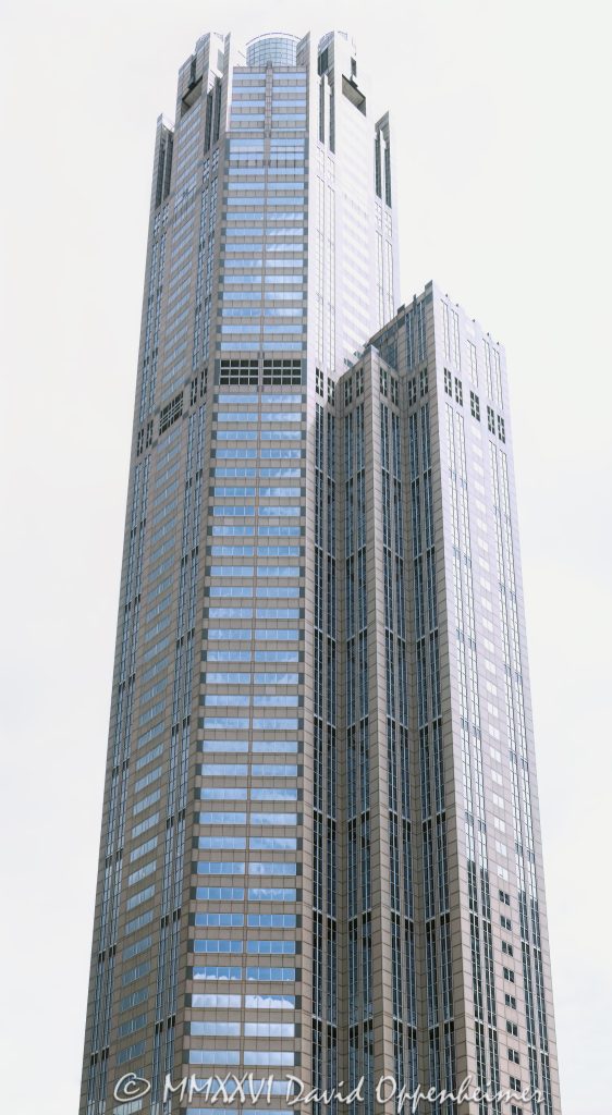 311 South Wacker Drive office tower in downtown Chicago, Illinois, located in the Loop near Willis Tower and Chicago Union Station. Postmodern commercial skyscraper architecture by Kohn Pedersen Fox featuring a granite and glass exterior, a distinctive cylindrical crown, and a large glass-ceilinged winter garden. Completed in 1990, the 65-story office tower was the tallest reinforced concrete structure in the world at the time of completion. - © 2026 David Oppenheimer - Performance Impressions photography archives https://performanceimpressions.com 311 South Wacker, 311 South Wacker Drive, 311 S Wacker, South Wacker Drive, Wacker Drive, Chicago, Chicago Illinois, Illinois, United States, 60606, Downtown Chicago, Chicago Loop, Chicago River, Willis Tower, Union Station, architecture, Chicago architecture, architectural photography, urban architecture, postmodern architecture, modern architecture, contemporary architecture, postmodern skyscraper, skyscraper, high-rise, office tower, building, tower, office building, commercial building, corporate tower, corporate headquarters, commercial real estate, corporate real estate, real estate, business district, financial district, commercial architecture, corporate architecture, downtown, urban, glass tower, glass building, glass facade, granite facade, granite exterior, reflective glass, curtain wall, facade, building exterior, reflections, iconic building, American architecture, Illinois architecture, exterior, daylight, financial center, business center, Class A office building, Chicago skyscraper, Chicago office tower, downtown office tower, commercial tower, office architecture, Loop district, Kohn Pedersen Fox, Kohn Pedersen Fox Associates, KPF, HKS, Lincoln Property Company, J A Jones Construction, reinforced concrete, concrete skyscraper, winter garden, glass ceiling, cylindrical crown, illuminated crown, crown, postmodern crown, commercial photography, commercial imagery, image licensing, licensing, photography licensing, David Oppenheimer, vertical, 1-15156784411