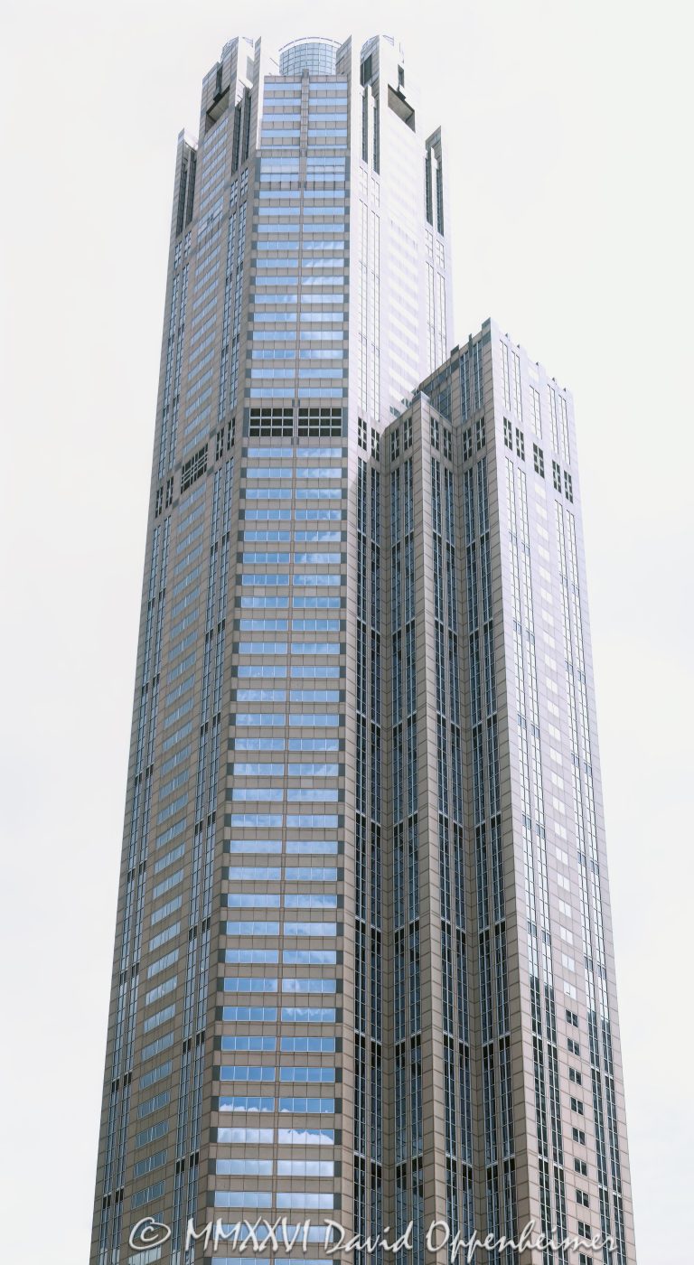 311 South Wacker Drive office tower in downtown Chicago, Illinois, located in the Loop near Willis Tower and Chicago Union Station. Postmodern commercial skyscraper architecture by Kohn Pedersen Fox featuring a granite and glass exterior, a distinctive cylindrical crown, and a large glass-ceilinged winter garden. Completed in 1990, the 65-story office tower was the tallest reinforced concrete structure in the world at the time of completion. - © 2026 David Oppenheimer - Performance Impressions photography archives https://performanceimpressions.com 311 South Wacker, 311 South Wacker Drive, 311 S Wacker, South Wacker Drive, Wacker Drive, Chicago, Chicago Illinois, Illinois, United States, 60606, Downtown Chicago, Chicago Loop, Chicago River, Willis Tower, Union Station, architecture, Chicago architecture, architectural photography, urban architecture, postmodern architecture, modern architecture, contemporary architecture, postmodern skyscraper, skyscraper, high-rise, office tower, building, tower, office building, commercial building, corporate tower, corporate headquarters, commercial real estate, corporate real estate, real estate, business district, financial district, commercial architecture, corporate architecture, downtown, urban, glass tower, glass building, glass facade, granite facade, granite exterior, reflective glass, curtain wall, facade, building exterior, reflections, iconic building, American architecture, Illinois architecture, exterior, daylight, financial center, business center, Class A office building, Chicago skyscraper, Chicago office tower, downtown office tower, commercial tower, office architecture, Loop district, Kohn Pedersen Fox, Kohn Pedersen Fox Associates, KPF, HKS, Lincoln Property Company, J A Jones Construction, reinforced concrete, concrete skyscraper, winter garden, glass ceiling, cylindrical crown, illuminated crown, crown, postmodern crown, commercial photography, commercial imagery, image licensing, licensing, photography licensing, David Oppenheimer, vertical, 1-15156784411