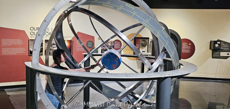 Adler Planetarium armillary sphere and Earth globe on Chicago’s Museum Campus in Chicago, Illinois, with a young visitor examining the Earth-centered astronomical model. Concentric rings illustrate celestial coordinates and the apparent movement of the Sun, connecting astronomy, navigation, geography and historical scientific observation – © 2026 David Oppenheimer – Performance Impressions photography archives https://performanceimpressions.com Adler Planetarium, Adler, Adler Chicago, Adler Planetarium Chicago, Chicago Adler, Adler museum, Adler astronomy, Adler Planetarium interior, Adler exhibit, Adler Planetarium exhibit, armillary sphere, armillary, sphere, Earth globe, globe, Earth, astronomical model, astronomy model, geocentric model, geocentric, Earth-centered, celestial sphere, celestial, celestial coordinates, ecliptic, celestial equator, astronomical instrument, scientific instrument, astronomy, planetarium, museum, science museum, astronomy museum, science, astronomy education, science education, STEM, education, learning, navigation, celestial navigation, geography, cartography, mapping, map, coordinates, latitude, longitude, Sun, solar path, cosmos, universe, astronomy history, historic astronomy, scientific history, concentric rings, rings, astronomy exhibit, science exhibit, museum exhibit, Astronomy in Culture, girl, child, young visitor, museum visitor, student, Chicago Museum Campus, Museum Campus, Museum Campus Chicago, Chicago museum, Chicago museums, Chicago astronomy, Chicago science, Chicago education, Chicago attraction, South Loop, South Loop Chicago, Chicago, Chicago Illinois, Illinois, 1300 South DuSable Lake Shore Drive, 1300 S DuSable Lake Shore Drive, DuSable Lake Shore Drive, 60605, Adler Planetarium and Astronomy Museum, Adler Planetarium & Astronomy Museum, United States, USA, museum photography, astronomy photography, science photography, educational photography, travel photography, editorial photography, licensing, image licensing, commercial imagery, photography licensing, art, print, fine art, commercial photography, David Oppenheimer, Performance Impressions, horizontal, 1-15213827141
