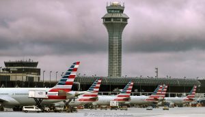 Chicago O’Hare International Airport Terminal 3 with American Airlines Jets Chicago O’Hare International Airport Terminal 3 with American Airlines jets parked at the K gates beneath dark clouds, with the jet bridges, the airport apron, and an air traffic control tower in the background. The terminal section at the left edge houses the American Airlines flagship lounge, the Admirals Club – © 2026 David Oppenheimer – Performance Impressions photography archives https://performanceimpressions.com Chicago O’Hare International Airport, Chicago O’Hare Airport, O’Hare International Airport, O’Hare Airport, Chicago O’Hare, Chicago airport, ORD, O’Hare Terminal 3, Chicago O’Hare Terminal 3, Terminal 3, Terminal 3 Chicago, American Airlines jets, American Airlines O’Hare, American Airlines ORD, American Airlines Terminal 3, O’Hare K gates, Terminal 3 K gates, K gates, Concourse K, K Concourse, 10000 W O’Hare Avenue, 10000 West O’Hare Avenue, O’Hare, O’Hare Chicago, O’Hare community area, Northwest Side Chicago, Chicago Illinois, Chicago IL, 60666, Orchard Field, former Orchard Field, airport, terminal, airport terminal, gates, airport gates, boarding gates, gate area, aviation, commercial aviation, air travel, airline, airlines, jet, jets, aircraft, airplanes, airliners, passenger jets, passenger aircraft, commercial aircraft, parked jets, parked aircraft, aircraft parking, American Airlines, American, American Airlines Group, AAdvantage, Oneworld, American Airlines hub, airline hub, hub airport, American Airlines fleet, American Airlines livery, aircraft tails, jet bridge, jet bridges, apron, airport apron, ramp, airport ramp, tarmac, ground operations, airline operations, airport operations, airfield, terminal building, terminal exterior, airport exterior, building exterior, facade, air traffic control, air traffic control tower, airport control tower, control tower, ATC, ATC tower, O’Hare control tower, FAA, Federal Aviation Administration, Chicago Department of Aviation, CDA, American Airlines Flagship Lounge, American Flagship Lounge, Flagship Lounge, Flagship Lounge ORD, American Airlines Admirals Club, Admirals Club, Admirals Club ORD, Admirals Club lounge, American Airlines lounge, Terminal 3 lounge, H K connector, dark clouds, cloudy sky, overcast sky, cloud cover, weather, airport weather, aviation weather, dramatic sky, airport architecture, terminal architecture, transportation architecture, airport photography, aviation photography, transportation, travel, business travel, Chicago aviation, Illinois aviation, United States, licensing, image licensing, commercial imagery, photography licensing, art, print, fine art, commercial photography, David Oppenheimer, horizontal, 1-15213827141