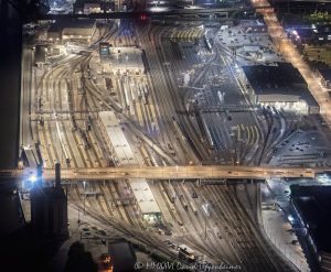 BNSF Metra Railroad Yard and Amtrak Chicago Car Yard Night Aerial Photo BNSF Metra Railroad Yard and Amtrak Chicago Car Yard night aerial photo in Chicago, Illinois, showing dense railroad tracks, switch tracks, rail yards, and passenger rail infrastructure south of Chicago Union Station. The view includes the Roosevelt Road bridge, Union Station Power House, and rail corridor near South Canal Street in the Near West Side and South Loop area – © 2026 David Oppenheimer – Performance Impressions aerial photography archives https://performanceimpressions.com BNSF Metra Railroad Yard, BNSF Metra yard, BNSF railroad yard, Metra railroad yard, Metra yard, BNSF Chicago, Metra Chicago, Amtrak Chicago Car Yard, Amtrak car yard, Amtrak Chicago, Chicago rail yard, Chicago railroad yard, Chicago train yard, rail yard, railroad yard, train yard, rail tracks, railroad tracks, train tracks, switch tracks, rail switches, track switches, rail junction, railroad junction, rail infrastructure, railroad infrastructure, passenger rail, commuter rail, intercity rail, rail corridor, Chicago Union Station, Union Station, Union Station Power House, Roosevelt Road bridge, Roosevelt Road, 1231 South Canal, 1231 South Canal Street, 1231 S Canal, South Canal Street, Canal Street, 60607, Chicago, Chicago Illinois, Illinois, United States, Near West Side, South Loop, downtown Chicago, aerial, night aerial, aerial photo, aerial photograph, aerial photography, aerial photographer, aerial view, aerial image, nighttime aerial, night photography, night photo, railroad photography, rail photography, transportation photography, infrastructure photography, transportation, transportation infrastructure, urban infrastructure, industrial infrastructure, railway, railroad, trains, Metra, BNSF, Amtrak, bridge, overpass, city lights, lighting, rail lighting, commercial photography, commercial imagery, image licensing, licensing, photography licensing, David Oppenheimer, 1-15156784411