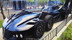 Six-Wheel Batmobile at Six Flags Great America near Chicago Six-wheel Batmobile at Six Flags Great America near Chicago in Gurnee, Illinois, shown in close-up in the amusement park’s DC Universe themed area. The futuristic black Batman vehicle features a multi-axle design with four closely spaced front wheels, an aircraft-style cockpit canopy, tall vertical batwing fins and multiple exposed exhaust pipes, creating a distinctive comic-book-inspired interpretation of Batman’s iconic car – © 2026 David Oppenheimer – Performance Impressions photography archives https://performanceimpressions.com Batmobile, Six Flags Batmobile, Six Flags Great America Batmobile, Great America Batmobile, Batman Batmobile, Batmobile Chicago, Chicago Batmobile, Batmobile Illinois, six-wheel Batmobile, six-wheeled Batmobile, six wheels, six-wheel vehicle, six-wheeled vehicle, multi-axle, multi-axle vehicle, dual front axle, twin front axle, front axles, four front wheels, Batman car, Batman vehicle, Batmobile car, Batmobile vehicle, Batmobile display, Batman display, vehicle display, display vehicle, show car, superhero car, superhero vehicle, futuristic Batmobile, futuristic car, futuristic vehicle, custom car, custom vehicle, black Batmobile, black car, black vehicle, automobile, automotive, car, vehicle, transportation, automotive design, vehicle design, futuristic design, aerodynamic, aerodynamic design, bodywork, sculpted bodywork, vehicle exterior, car exterior, exterior, close up, close-up, detail, vehicle detail, automotive detail, wheels, wheel, tires, tire, wheel design, front wheels, cockpit, cockpit canopy, aircraft-style cockpit, aircraft cockpit, canopy, enclosed cockpit, windshield, windscreen, batwing fins, bat wings, rear fins, vertical fins, tail fins, Batman fins, exhaust, exhaust pipes, eight exhaust pipes, multiple exhausts, side exhaust, exhaust detail, pipes, side intakes, air intakes, vents, Batman, BATMAN, Batman DC, DC Batman, DC Comics, DC Comics Batman, DC, DC Universe, Six Flags DC Universe, DC Universe Six Flags, Great America DC Universe, DC Universe Chicago, DC Universe Illinois, superhero, superheroes, DC superhero, comic book, comics, comic books, comic character, comic superhero, superhero icon, Batman icon, Batman memorabilia, DC memorabilia, Batman attraction, Batman theme, Batman themed, Batman experience, themed vehicle, themed entertainment, comic-book inspired, comic inspired, fantasy vehicle, fictional vehicle, entertainment vehicle, photo op, Six Flags Great America, Six Flags Great America Chicago, Great America Chicago, Great America Illinois, Six Flags Chicago, Six Flags Illinois, Six Flags, Great America, amusement park, theme park, amusement parks, theme parks, amusement park attraction, theme park attraction, park attraction, attraction, attractions, entertainment, family entertainment, tourist attraction, travel destination, destination, Gurnee, Gurnee Illinois, Gurnee IL, Illinois, Lake County, Lake County Illinois, northern Illinois, Chicagoland, Chicago area, Chicago, Chicago Illinois, Chicago attraction, Chicago attractions, Chicago theme park, Chicago amusement park, Chicago tourism, Chicago travel, Chicago trip, Chicago vacation, Visit Chicago, visit Chicago, Illinois attraction, Illinois attractions, Illinois tourism, Illinois travel, Visit Illinois, Midwest, Midwest attraction, Midwest amusement park, Midwest theme park, tourism, travel, sightseeing, vacation, summer, summer travel, Great America Parkway, 1 Great America Parkway, Grand Avenue, Route 132, Interstate 94, I-94, 60031, United States, USA, Warner Bros, Warner Brothers, Warner Bros Discovery, Warner Bros. Discovery, WBD, Warner Bros Themed Entertainment, DC Studios, Six Flags Entertainment Corporation, Six Flags Entertainment, Six Flags company, Six Flags stock, FUN, NYSE FUN, Cedar Fair, amusement park photography, theme park photography, Batmobile photography, Batman photography, DC photography, superhero photography, automotive photography, car photography, vehicle photography, detail photography, entertainment photography, travel photography, tourism photography, editorial photography, commercial photography, fine art photography, Batmobile art, Batman art, superhero art, DC art, automotive art, car art, vehicle art, Six Flags art, Great America art, Chicago art, Batmobile print, Batman print, superhero print, automotive print, car print, photographic print, fine art print, archival print, gallery print, collector print, wall art, office art, licensing, image licensing, commercial imagery, photography licensing, art, print, fine art, commercial photography, David Oppenheimer, Performance Impressions, Performance Impressions photography archives, horizontal, 1-15156784411