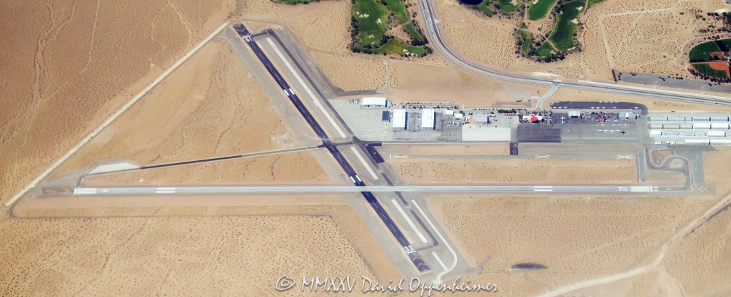 Boulder City Municipal Airport Aerial View Boulder City Municipal Airport with Runway 11 in the foreground, surrounded by beige desert terrain near Boulder City, Nevada – © 2025 David Oppenheimer – Performance Impressions aerial photography archives – https://performanceimpressions.com Boulder City, Boulder City Airport, Boulder City Municipal, KBVU, Runway 33, Runway 15, airport, airfield, municipal airport, regional airport, public airport, general aviation, aviation, aircraft, airplanes, plane, planes, tarmac, hangar, hangars, flight, flying, pilot, airstrip, landing strip, taxiway, terminal, control tower, ramp, apron, departure, takeoff, landing, airspace, navigation, VFR, flight path, flight operations, flight school, aviation training, sightseeing tours, charter flights, Scenic Airlines, Grand Canyon flights, helicopter tours, desert, sand, beige, dry terrain, Nevada, Clark County, southern Nevada, Southwest, desert Southwest, Las Vegas area, western United States, United States, infrastructure, topography, elevation, remote airport, small airport, travel, tourism, transportation, executive travel, business aviation, aerial, aerial view, aerial photo, aerial photography, drone view, sky view, top down, horizon, landscape, desert view, open space, minimalism, scenic, colorful, wall art, fine art, photography print, horizontal, 1-14993092111