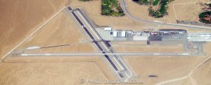 Boulder City Municipal Airport with Runway 11 in the foreground, surrounded by beige desert terrain near Boulder City, Nevada – © 2025 David Oppenheimer – Performance Impressions aerial photography archives – https://performanceimpressions.com Boulder City, Boulder City Airport, Boulder City Municipal, KBVU, Runway 33, Runway 15, airport, airfield, municipal airport, regional airport, public airport, general aviation, aviation, aircraft, airplanes, plane, planes, tarmac, hangar, hangars, flight, flying, pilot, airstrip, landing strip, taxiway, terminal, control tower, ramp, apron, departure, takeoff, landing, airspace, navigation, VFR, flight path, flight operations, flight school, aviation training, sightseeing tours, charter flights, Scenic Airlines, Grand Canyon flights, helicopter tours, desert, sand, beige, dry terrain, Nevada, Clark County, southern Nevada, Southwest, desert Southwest, Las Vegas area, western United States, United States, infrastructure, topography, elevation, remote airport, small airport, travel, tourism, transportation, executive travel, business aviation, aerial, aerial view, aerial photo, aerial photography, drone view, sky view, top down, horizon, landscape, desert view, open space, minimalism, scenic, colorful, wall art, fine art, photography print, horizontal, 1-14993092111