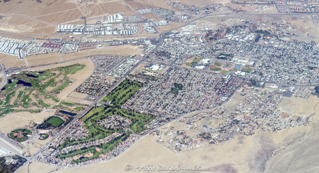 Boulder City Nevada Aerial View Boulder City, Nevada seen from above, showing Boulder Creek Golf Club, Boulder City Golf Course, Boulder City High School, and surrounding desert neighborhoods – © 2025 David Oppenheimer – Performance Impressions aerial photography archives – https://performanceimpressions.com Boulder City, Boulder City Nevada, Boulder City aerial, Boulder City real estate, Boulder Creek Golf Club, Boulder City Golf Course, Southern Nevada Veterans Memorial Cemetery, Boulder City High School, Nature Discovery Trail and Rock Garden, Bootleg Canyon Park Trail Head, golf, golf course, golf club, golfing, fairway, greens, public golf, municipal golf, desert golf, aerial, aerial view, aerial photo, aerial photography, top down, map view, layout, desert, sand, beige, dry terrain, desert city, city layout, cityscape, homes, neighborhoods, real estate, home lots, community planning, urban layout, grid layout, roadways, regional planning, residential development, Southern Nevada, Southwest, Clark County, Las Vegas area, Nevada town, outdoor space, recreation, green space, open space, elevation, scenic, travel, tourism, United States, western US, architecture, sky view, outdoor lifestyle, infrastructure, landscaping, nature trail, school campus, trailhead, park access, horizontal, 1-14993092111