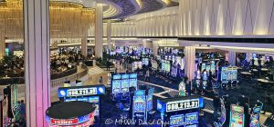 Fontainebleau Las Vegas Bleau Bar and casino floor in Las Vegas, Nevada - © 2025 David Oppenheimer - Performance Impressions travel photography archives - https://performanceimpressions.com casino, casino floor, Bleau Bar, chandelier, Fontainebleau Las Vegas, Fontainebleau, bar, slot machines, slots, floor, games, drinks, cocktails, drinking, lighting, Nevada, design, lights, crystal, crystal chandelier, Morris Lapidus, resort, Vegas, art deco, Fontainebleau Development, bowties, nightlife, Jeffrey Soffer, Carlos Zapata Studio, Bowtie Hospitality, bowtie, hospitality, Maurice Wooden, Koch Real Estate Investments, Las Vegas, money, betting, gaming, play, odds, win, gambling, wager, bet, luck, gamble, 2777 South Las Vegas Boulevard, 89109, interior design, architecture, decor, luxury resort, VIP, mixology, sparkle, shimmer, opulent, reflective, vacation, resort photography, resort photographer, real estate, luxury bar, United States, vertical, color, 1-14993092111