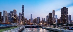 Chicago Harbor Lock with Chicago Skyline at Sunset Chicago Harbor Lock in Chicago, Illinois, connects Lake Michigan with the Chicago River beneath the downtown skyline after sunset. City lights line the waterfront under a blue-hour sky, with navigation lights marking the lock and the breakwater visible at the Chicago Harbor entrance – © 2026 David Oppenheimer – Performance Impressions photography archives https://performanceimpressions.com Chicago Harbor Lock, Chicago Harbor, Chicago Lock, Chicago River Lock, Chicago Harbor entrance, Lake Michigan, Chicago River, river mouth, Chicago skyline, Chicago cityscape, downtown Chicago, Chicago lakefront, Chicago waterfront, Chicago, Chicago Illinois, Chicago IL, Illinois, 60611, sunset, Chicago sunset, blue hour, twilight, dusk, evening, lights, city lights, skyline lights, building lights, navigation lights, illuminated skyline, sunset sky, clouds, cloudscape, dramatic sky, skyline, cityscape, landscape, downtown, city, urban, buildings, skyscrapers, towers, architecture, lake, water, river, harbor, harbor lock, navigation lock, lock, navigation, maritime, waterway, channel, breakwater, jetty, lock gates, infrastructure, lakefront, waterfront, shoreline, horizon, United States, licensing, image licensing, commercial imagery, photography licensing, art, print, fine art, commercial photography, David Oppenheimer, horizontal, 1-15213827141