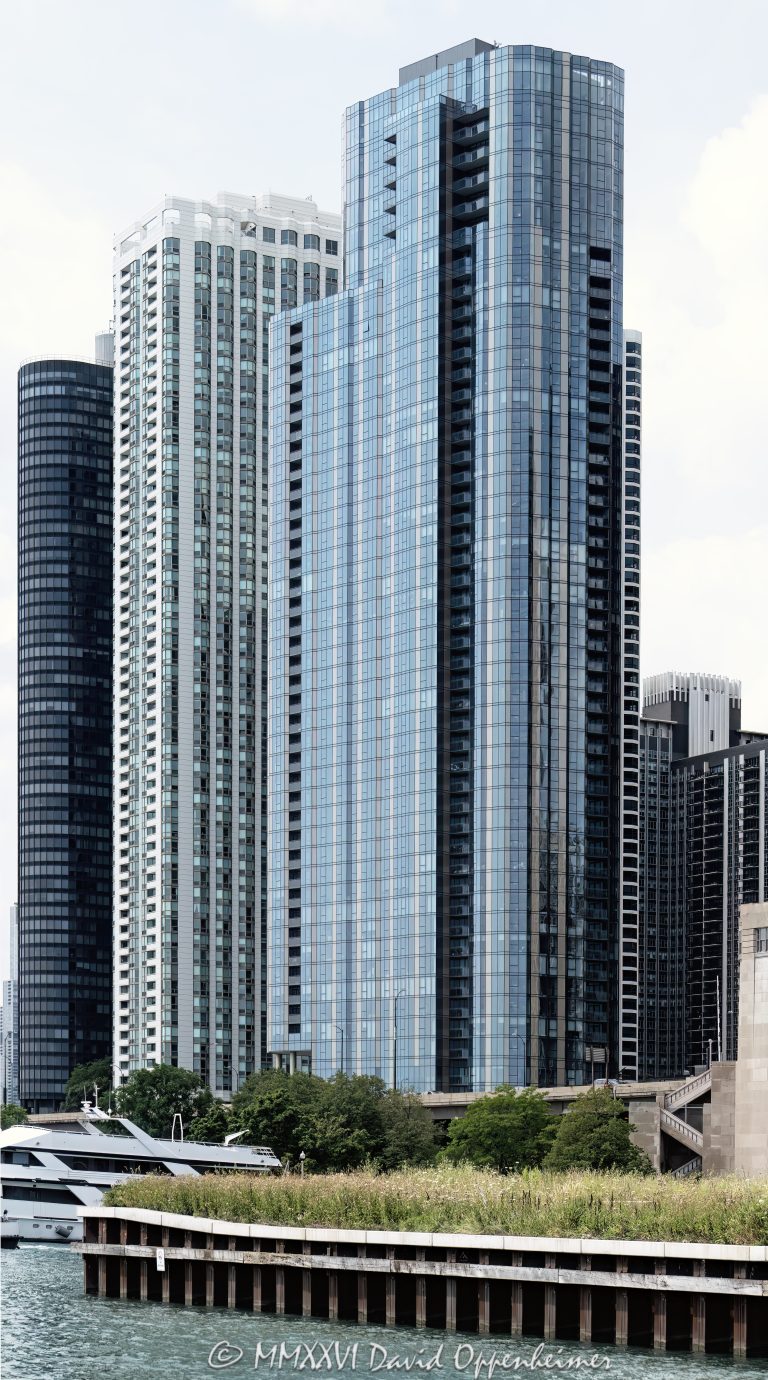 Cirrus Condominiums at 211 North Harbor Drive in Chicago, Illinois, located in Lakeshore East near Lake Michigan, the Chicago River, and DuSable Harbor. Contemporary residential high-rise architecture by bKL Architecture featuring a continuous glass facade, bronze-toned metal panels, balconies, and luxury condominium residences. The view primarily features Cirrus, with nearby 195 North Harbor Drive and 155 Harbor Condominium also visible along the Harbor Drive lakefront – © 2026 David Oppenheimer – Performance Impressions photography archives https://performanceimpressions.com Cirrus Condominiums, Cirrus Chicago, Cirrus, Cirrus condos, Cirrus condominium tower, 211 North Harbor, 211 North Harbor Drive, 211 N Harbor, North Harbor Drive, Harbor Drive, Lakeshore East, Chicago, Chicago Illinois, Illinois, United States, 60601, Downtown Chicago, Chicago Loop, New Eastside, Chicago River, Chicago lakefront, Lake Michigan, architecture, Chicago architecture, architectural photography, facade, building exterior, exterior, residential architecture, modern architecture, contemporary architecture, urban architecture, condominium tower, condominium building, condo tower, condo building, residential tower, residential building, high-rise, skyscraper, building, tower, glass tower, glass building, glass facade, continuous glass facade, bronze panels, metal panels, balconies, balcony, luxury condos, Chicago condos, Lakeshore East condos, downtown condos, residential real estate, condominium real estate, Chicago real estate, real estate, urban living, city living, lakefront living, riverfront architecture, waterfront, downtown, urban, iconic building, American architecture, Illinois architecture, daylight, bKL Architecture, Lendlease, Magellan Development Group, Cascade Park, Cascade Apartments, 195 North Harbor, 195 North Harbor Drive, 155 Harbor, 155 North Harbor, Harbor Point, 155 Harbor Condominium, commercial photography, commercial imagery, image licensing, licensing, photography licensing, art, print, fine art, David Oppenheimer, vertical, 1-15156784411