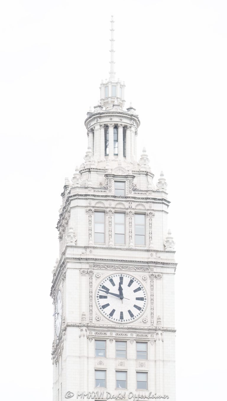 Wrigley Building clock tower at 400–410 North Michigan Avenue in Chicago, Illinois, located on the Magnificent Mile near the Chicago River. Historic terra cotta skyscraper architecture by Graham, Anderson, Probst & White featuring the building’s white clock tower, ornate facade, and landmark upper tower details. The clock reads 11:48 in this overcast close-up view of one of Chicago’s most recognizable buildings – © 2026 David Oppenheimer – Performance Impressions photography archives https://performanceimpressions.com Wrigley Building, Wrigley Building Chicago, Wrigley clock tower, Wrigley Building clock tower, clock tower, building clock, 400 North Michigan, 400 North Michigan Avenue, 410 North Michigan, 410 North Michigan Avenue, 400 N Michigan, 410 N Michigan, North Michigan Avenue, Michigan Avenue, Magnificent Mile, Chicago, Chicago Illinois, Illinois, United States, 60611, Downtown Chicago, Near North Side, Chicago Loop, Chicago River, architecture, Chicago architecture, architectural photography, facade, building exterior, exterior, historic architecture, terra cotta, white terra cotta, terra cotta facade, white facade, ornate facade, clock face, 11:48, tower detail, upper tower, landmark building, Chicago Landmark, historic building, skyscraper, high-rise, building, tower, office building, commercial building, commercial real estate, corporate real estate, real estate, Beaux-Arts architecture, Spanish Revival, French Renaissance, Graham Anderson Probst White, Graham Anderson Probst and White, GAPW, William Wrigley Jr, Wrigley Company, chewing gum company, Tribune Tower, DuSable Bridge, Michigan Avenue Bridge, white building, overcast, cloudy sky, soft light, daylight, urban architecture, American architecture, Illinois architecture, downtown, urban, tourism, travel, Chicago landmark, iconic building, commercial photography, commercial imagery, image licensing, licensing, photography licensing, art, print, fine art, David Oppenheimer, vertical, 1-15156784411