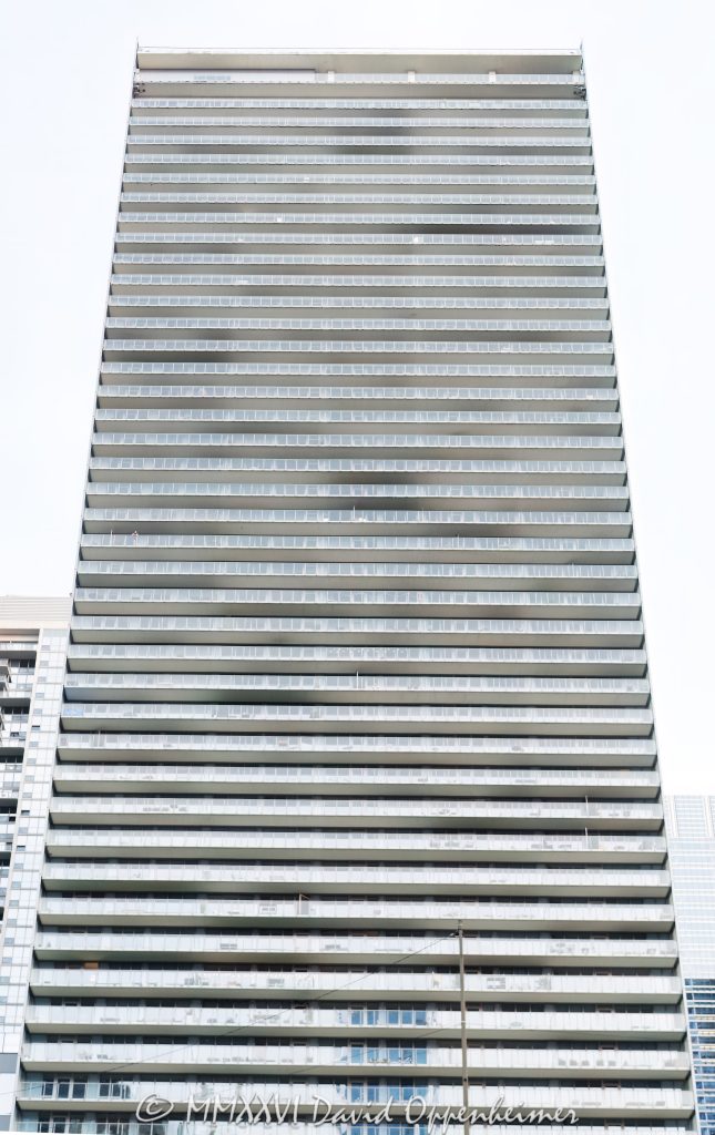 Coast at Lakeshore East at 345 East Wacker Drive in Chicago, Illinois, shown in a vertical exterior view of the rectangular glass rental tower with continuous balconies and a high-rise facade. Designed by bKL Architecture with Loewenberg Architects as architect of record and developed by Magellan Development Group, the Lakeshore East apartment building stands near the Chicago River, Lake Michigan, and Millennium Park – © 2026 David Oppenheimer – Performance Impressions photography archives https://performanceimpressions.com Coast at Lakeshore East, Coast Chicago, COAST, Coast Apartments, Coast at Lakeshore East Apartments, 345 East Wacker Drive, 345 E Wacker Drive, East Wacker Drive, Wacker Drive, Lakeshore East, New Eastside, Lakeshore East Chicago, New Eastside Chicago, downtown Chicago, Chicago Loop, Loop Chicago, Chicago, Chicago Illinois, Chicago IL, Illinois, 60601, facade, building exterior, exterior, tower exterior, glass facade, glass tower, glass high rise, rectangular tower, rectangular facade, curtain wall, glass curtain wall, aluminum window wall, translucent glass, fritted glass, Low-E glass, balconies, continuous balconies, glass balconies, glass handrails, horizontal balconies, apartment tower, residential tower, rental tower, high rise, high-rise, skyscraper, tower, building, apartment building, residential building, rental building, mixed-use tower, apartments, rental apartments, luxury apartments, Chicago apartments, downtown apartments, Lakeshore East apartments, New Eastside apartments, urban apartments, multifamily, multifamily housing, residential real estate, apartment real estate, Chicago real estate, Lakeshore East real estate, lakefront real estate, riverfront real estate, commercial real estate, real estate, Chicago River, riverfront, waterfront, lakefront, Lake Michigan, Millennium Park, Lakeshore East Park, Grant Park, DuSable Harbor, Chicago Harbor, architecture, architectural photography, Chicago architecture, residential architecture, high-rise architecture, modern architecture, Chicago modernism, bKL Architecture, bKL Architects, Loewenberg Architects, Magellan Development Group, James McHugh Construction, McHugh Construction, CSA, Mackie Consultants, Wolff Landscape Architecture, JPMorgan Asset Management, American Architecture Award, CTBUH, city views, skyline views, lake views, river views, rooftop deck, outdoor pool, landscaped deck, parking garage, smoke-free building, travel, tourism, destination, United States, licensing, image licensing, commercial imagery, photography licensing, art, print, fine art, commercial photography, David Oppenheimer, vertical, 1-15213827141
