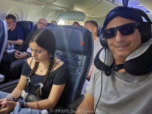 Flying on Delta Air Lines in First Class Father and daughter traveling together aboard a Delta Air Lines flight in the Delta First cabin, seated by the window with headphones, sunglasses, a travel pillow and sleep mask visible. The image presents a candid family air-travel moment in a premium airline cabin – © 2026 David Oppenheimer – Performance Impressions photography archives https://performanceimpressions.com Delta Air Lines, Delta Airlines, Delta flight, Delta First, Delta First Class, Delta Air Lines First Class, flying Delta, flying Delta Air Lines, Delta cabin, first class, first class flight, first class cabin, first class travel, first class seat, airline first class, premium cabin, premium travel, premium airline, airline upgrade, first class upgrade, flight upgrade, cabin upgrade, seat upgrade, upgraded seat, upgraded travel, air travel, airline travel, airplane travel, flying, flight, airline, airplane, aircraft, cabin, airline cabin, airplane cabin, aircraft cabin, airplane interior, aircraft interior, window seat, airplane window seat, airline seat, passenger seat, airline passenger, airplane passenger, passenger, traveler, air traveler, father daughter, father and daughter, father daughter travel, family travel, family flight, family vacation, parent child, parent and child, travel portrait, passenger portrait, airline portrait, inflight portrait, candid travel, candid portrait, travel lifestyle, photographer, travel photographer, aerial photographer, aerial photography, neck pillow, travel pillow, headphones, sunglasses, eye mask, sleep mask, airplane sleep mask, travel accessories, travel gear, inflight comfort, flight comfort, comfortable travel, frequent flyer, frequent flier, airline loyalty, premium seating, premium service, aviation, commercial aviation, commercial airline, passenger aviation, airline industry, air transportation, Delta Air Lines Inc, DAL, NYSE DAL, Delta stock, airline stock, aviation photography, airline photography, travel photography, editorial photography, lifestyle photography, family photography, portrait photography, David Oppenheimer, David Gordon Oppenheimer, David Oppenheimer photographer, David Oppenheimer photography, David Oppenheimer aerial photographer, Performance Impressions, Performance Impressions photography archives, licensing, image licensing, commercial imagery, photography licensing, art, print, fine art, commercial photography, horizontal, 1-15213827141