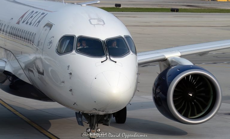 Delta Air Lines Airbus A220 at Chicago O’Hare International Airport, shown from the front as two pilots remain focused in the cockpit while the jet taxis near the terminal ramp. The horizontal aviation scene shows the aircraft nose, diagonal cockpit windshields, Delta livery, and part of a wing-mounted engine in Chicago, Illinois – © 2026 David Oppenheimer – Performance Impressions photography archives https://performanceimpressions.com Delta Air Lines Airbus A220, Delta Airbus A220, Delta A220, Airbus A220, A220, Delta Air Lines, Delta Airlines, Delta jet, Delta aircraft, Delta plane, Delta livery, Delta Air Lines livery, Delta pilot, Delta pilots, pilots, pilot, piloting, cockpit, flight deck, cockpit crew, flight crew, airline pilots, aviation crew, focused pilots, pilot concentration, aircraft cockpit, cockpit windshields, diagonal windshields, slanted windshields, aircraft nose, jet nose, front of plane, nose section, wing-mounted engine, jet engine, turbofan engine, taxiing aircraft, taxiing jet, airport ramp, airport apron, terminal ramp, jetway, gate approach, airline operations, ground operations, airport operations, commercial aviation, passenger jet, commercial jet, narrowbody jet, narrow-body aircraft, airliner, aircraft, airplane, jet, aviation, air travel, transportation, travel, business travel, airport, Chicago O’Hare International Airport, O’Hare International Airport, Chicago O’Hare Airport, O’Hare Airport, Chicago O’Hare, ORD, KORD, 10000 W O’Hare Avenue, O’Hare, Chicago, Chicago Illinois, Chicago IL, Illinois, 60666, SkyTeam, SkyTeam airline, SkyTeam Alliance, DAL, DAL stock, Delta stock, NYSE DAL, Delta Air Lines Inc, airline stock, airline industry, travel industry, transportation industry, corporate aviation, airport photography, aviation photography, aircraft photography, airline photography, commercial photography, editorial photography, United States, licensing, image licensing, commercial imagery, photography licensing, art, print, fine art, commercial photography, David Oppenheimer, horizontal, 1-15213827141