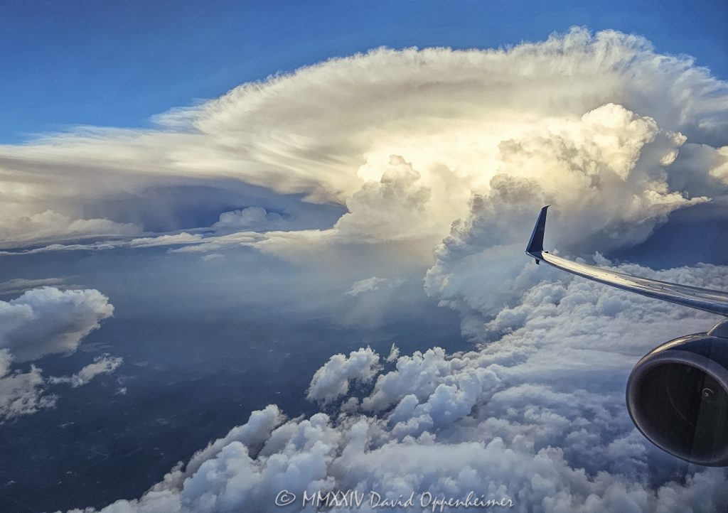 Flying by a Cumulonimbus supercell storm cloud with an anvil at altitude - © 2024 David Oppenheimer - Performance Impressions photography archives - https://performanceimpressions.com supercell, supercell storm cloud, Cumulonimbus, anvil, altitude, jet, plane, aerial, aerial view, wall cloud, storm, meteorology, weather, stormy, thunderstorm, cloud, precipitation, flight, fly, travel, air travel, window seat, Delta, Delta Air Lines, DAL, DAL stock, David Oppenheimer, horizontal, square, color, United States, 1-13985601741,