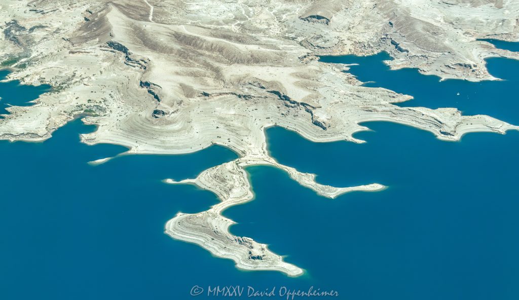 Lake Mead Shoreline and Battleship Rock in Lake Mead National Recreation Area Aerial View Lake Mead shoreline and Battleship Rock in the Lake Mead National Recreation Area between Swallow Bay and Water Barge Cove near Callville Bay, Nevada aerial view – © 2025 David Oppenheimer – Performance Impressions aerial photography archives - https://performanceimpressions.com Lake Mead, Lake Mead aerial, Swallow Bay, Water Barge Cove, Callville Bay, lakefront, shoreline, shore, waterline, water level, Circle of Rocks, Lovers Cove, Hidden Cove, Hideaway Cove, Quiet Cove, lake, lake aerial, desert lake, Colorado River, Clark County, Lake Mead National Recreation Area, Nevada, water, drinking water, water supply, river, plateau, siltstone, sandstone, boating, channel, geology, ravine, canyon, valley, aerial, aerial view, mountains, arid, barren, vacation, gorge, rim, red, cliffs, aerial photographer, Battleship Rock aerial, wash, erosion, rocks, erode, scenic, landscape, overlook, rocky, visit, travel, American West, desert, high desert, advertising, United States, USA, America, horizontal, 1-14993092111