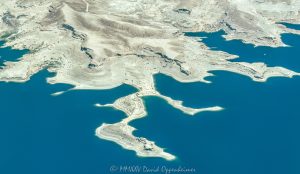 Lake Mead shoreline and Battleship Rock in the Lake Mead National Recreation Area between Swallow Bay and Water Barge Cove near Callville Bay, Nevada aerial view – © 2025 David Oppenheimer – Performance Impressions aerial photography archives - https://performanceimpressions.com Lake Mead, Lake Mead aerial, Swallow Bay, Water Barge Cove, Callville Bay, lakefront, shoreline, shore, waterline, water level, Circle of Rocks, Lovers Cove, Hidden Cove, Hideaway Cove, Quiet Cove, lake, lake aerial, desert lake, Colorado River, Clark County, Lake Mead National Recreation Area, Nevada, water, drinking water, water supply, river, plateau, siltstone, sandstone, boating, channel, geology, ravine, canyon, valley, aerial, aerial view, mountains, arid, barren, vacation, gorge, rim, red, cliffs, aerial photographer, Battleship Rock aerial, wash, erosion, rocks, erode, scenic, landscape, overlook, rocky, visit, travel, American West, desert, high desert, advertising, United States, USA, America, horizontal, 1-14993092111