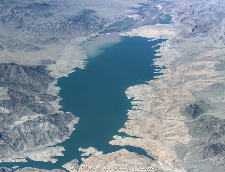 Lake Mead where the Colorado River flows into the Gregg Basin section of the reservoir, depositing silt forming a lacustrine delta near Powell Bay and Sandy Point on the Nevada–Arizona border aerial view – © 2025 David Oppenheimer – Performance Impressions aerial photography archives – https://performanceimpressions.com Lake Mead, Lake Mead aerial, Gregg Basin, Sandy Point, lake, lake aerial, desert lake, South Cove, Scanlon Bay, Crappie Cove, Sunfish Cove, Devils Cove, South Howland Cove, Howland Cove, Hualapai Island, Channel Island, reservoir, drinking water, water supply, water level, level, Channel Reef, Virgin Reef, inflow, Colorado River inflow, river mouth, river delta, Colorado Plateau, Channel Bay, Granite Cove, Reef Bay, Gold Cross Bay, Powell Bay, Wagon Trail Bay, Smith Bay, North Bay, Iceberg Canyon, Iceberg Ridge, Boundary Point, Powell Mountain, Round Rock Point, Hiller Mountains, Gold Cross Peak, Indian Hills, Hells Kitchen, Wheeler Ridge, Arizona, silt, sediment, river, Clark County, Lake Mead National Recreation Area, plateau, siltstone, channel fill, boating, lacustrine, shoreline, lakefront, delta, channel, geology, ravine, canyon, valley, valley aerial, aerial, aerial view, mountains, arid, barren, vacation, gorge, rim, red, red rocks, cliffs, aerial photographer, limestone, Redwall Limestone, wash, erosion, rocks, erode, scenic, landscape, overlook, sandstone, rocky, canyon walls, visit, travel, American West, desert, high desert, advertising, United States, USA, America, vertical, 1-14993092111