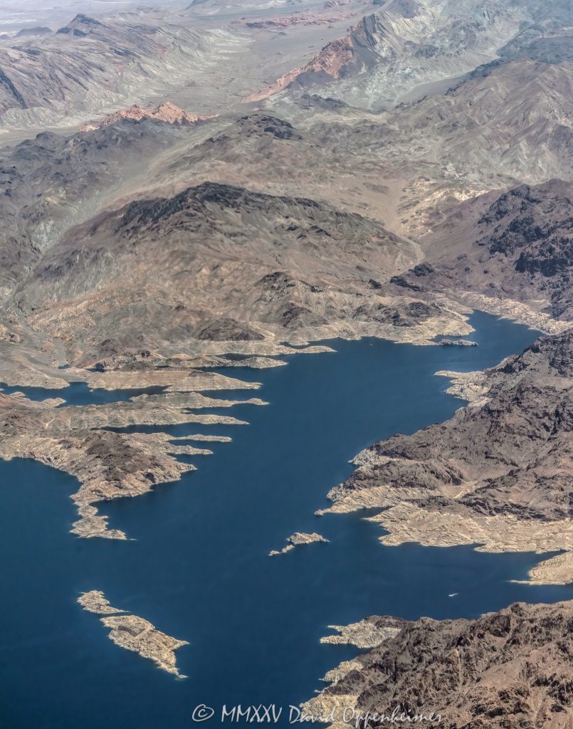 Lake Mead Shoreline by Auxiliary Point in Hamblin Bay in Boulder Canyon Aerial View Lake Mead shoreline by Auxiliary Point and Skrillex Rocks in Hamblin Bay, Boulder Canyon, Lake Mead National Recreation Area, Nevada aerial view – © 2025 David Oppenheimer – Performance Impressions aerial photography archives - https://performanceimpressions.com Lake Mead, Lake Mead aerial, Skrillex Rocks, Auxiliary Point, Sandy Cove, Hamblin Bay, Rufus Cove, Rotary Cove, Bighorn Cove, Bearing Cove, Indian Canyon Cove, Boulder Canyon, lakefront, shoreline, shore, waterline, water level, lake, lake aerial, desert lake, Colorado River, Clark County, Lake Mead National Recreation Area, Arizona, Nevada, Hamblin Mountain, Bearing Peak, Pinto Valley, Razorback Ridge, Canyon Point, water, drinking water, water supply, river, plateau, siltstone, sandstone, boating, channel, geology, ravine, canyon, valley, aerial, aerial view, mountains, arid, barren, vacation, gorge, rim, red, cliffs, wash, erosion, rocks, erode, scenic, landscape, overlook, rocky, visit, travel, American West, desert, high desert, advertising, aerial photographer, United States, USA, America, vertical, 1-14993092111