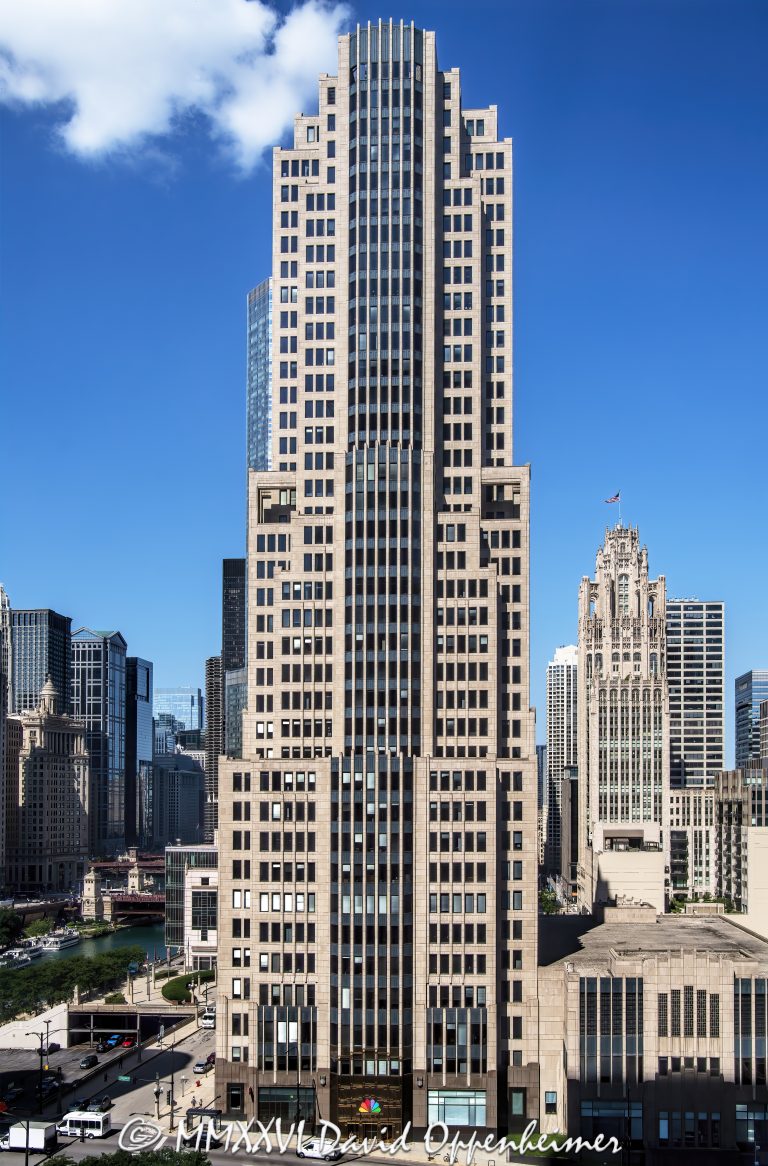 NBC Tower in Chicago, with the Art Deco-influenced postmodern facade and stepped upper tower of Skidmore, Owings & Merrill’s office skyscraper at 455 North Cityfront Plaza Drive. The Cityfront Plaza landmark houses NBC Chicago and WMAQ-TV near the Magnificent Mile and Chicago River – © 2026 David Oppenheimer – Performance Impressions photography archives https://performanceimpressions.com NBC Tower 455 N Cityfront Plaza Dr, NBC Tower, 455 North Cityfront Plaza Drive, 455 N Cityfront Plaza Drive, NBC Tower Chicago, NBC Tower Chicago IL 60611, 454 North Columbus Drive, 454 N Columbus Dr, NBC Tower at Cityfront Plaza, Cityfront Plaza, Cityfront Center, Chicago NBC Tower, NBC Chicago, NBC 5 Chicago, WMAQ-TV, NBCUniversal, Comcast NBCUniversal, Telemundo Chicago, WSNS-TV, Magnificent Mile, Streeterville, Near North Side, downtown Chicago, Chicago River, North Columbus Drive, Cityfront Plaza Drive, facade, building exterior, exterior, architecture, building, tower, office tower, office building, skyscraper, Chicago skyscraper, Chicago architecture, Chicago office tower, postmodern architecture, Art Deco influence, Art Deco inspired, stepped tower, limestone facade, granite facade, glass facade, spire, broadcast tower, media headquarters, television studio, broadcast studio, Skidmore Owings Merrill, SOM, Adrian Smith architect, Tishman Speyer, Metropolis Investment Holdings, Illinois architecture, United States, Licensing, image licensing, commercial imagery, photography licensing, art, print, fine art, commercial photography, David Oppenheimer, vertical, 1-15156784411