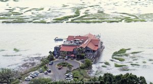 Old Oyster Factory restaurant at 101 Marshland Road on Hilton Head Island, South Carolina, aerial view - © 2024 David Oppenheimer - Performance Impressions photography archives - https://performanceimpressions.com Old Oyster Factory, Old Oyster Factory Restaurant, 101 Marshland Rd, Bram Landing, Broad Creek, creek, marsh, saltmarsh, wetlands, seafood, seafood restaurant, restaurant, oysters, raw bar, rustic, rustic-chic, dining, scenic, scenic view, waterside seating, private pier, lounge, bar, live music, music, happy hour, South Carolina, Hilton Head, Hilton Head Island, Hilton Head aerial, Town of Hilton Head, Lowcountry, Hilton Head island real estate, Hilton Head real estate, real estate, photography, aerial photographer, aerial view, aerial, building, architecture, 29928, David Oppenheimer, David Gordon Oppenheimer, United States, color, horizontal, 1-13726821381,