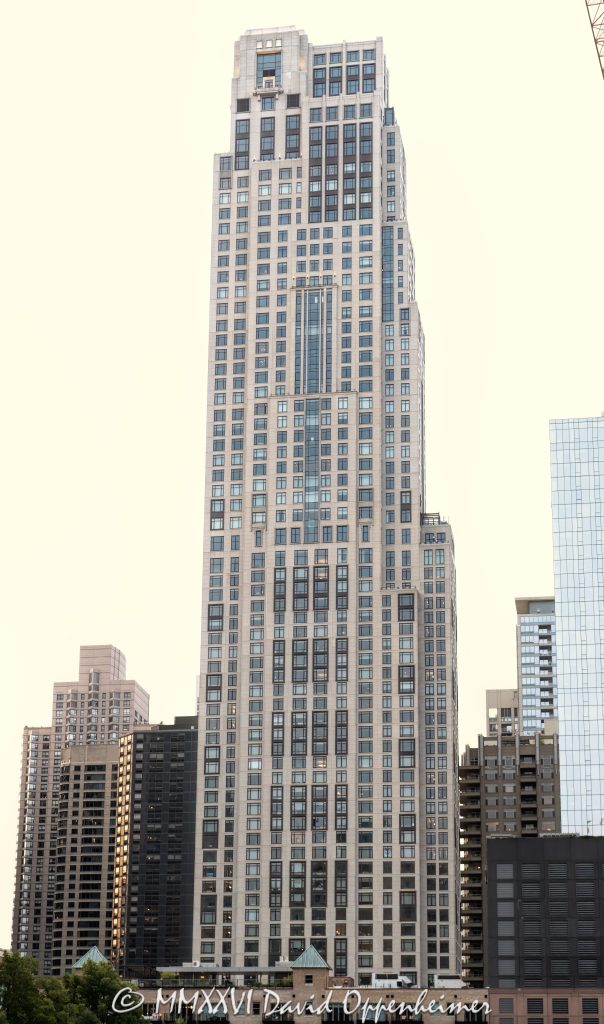 One Bennett Park Apartments rise above Streeterville in Chicago, Illinois. Designed by Robert A.M. Stern Architects for Related Midwest, the Art Deco–inspired residential tower combines luxury rentals and condominiums, with a precast-concrete façade articulated by punched windows, stacked bays, vertical setbacks and an asymmetrical crown – © 2026 David Oppenheimer – Performance Impressions photography archives https://performanceimpressions.com One Bennett Park Apartments, 514 North Peshtigo Court, One Bennett Park, 451 East Grand Avenue, 451 E Grand, One Bennett Park Chicago, One Bennett Park rentals, One Bennett Park condominiums, Streeterville, River East, Chicago, Illinois, Cook County, Near North Side, downtown Chicago, building exterior, facade, exterior, tower exterior, upper tower, residential tower, residential skyscraper, high-rise, skyscraper, Chicago skyscraper, precast concrete facade, precast concrete, limestone base, punched windows, bay windows, stacked bays, metal detailing, vertical setbacks, asymmetrical crown, crowning lantern, Art Deco, Art Deco architecture, Chicago architecture, Streeterville architecture, architecture, tower, building, apartment building, apartments, rental apartments, luxury rentals, luxury apartments, condominiums, luxury condos, residential building, multifamily housing, real estate, luxury real estate, Chicago apartments, Streeterville apartments, Chicago condos, Robert A.M. Stern Architects, RAMSA, Robert A.M. Stern, GREC Architects, GREC Studio, Related Midwest, Related Companies, Related Rentals, Related Management, Lendlease, Lend Lease U.S. Construction, Thornton Tomasetti, structural engineering, Michael Van Valkenburgh Associates, Bennett Park, LEED Silver, sustainable design, USA, United States, 60611, architectural photography, real estate photography, building photography, urban photography, commercial architecture, Licensing, image licensing, commercial imagery, photography licensing, art, print, fine art, commercial photography, David Oppenheimer, vertical, 1-15213827141