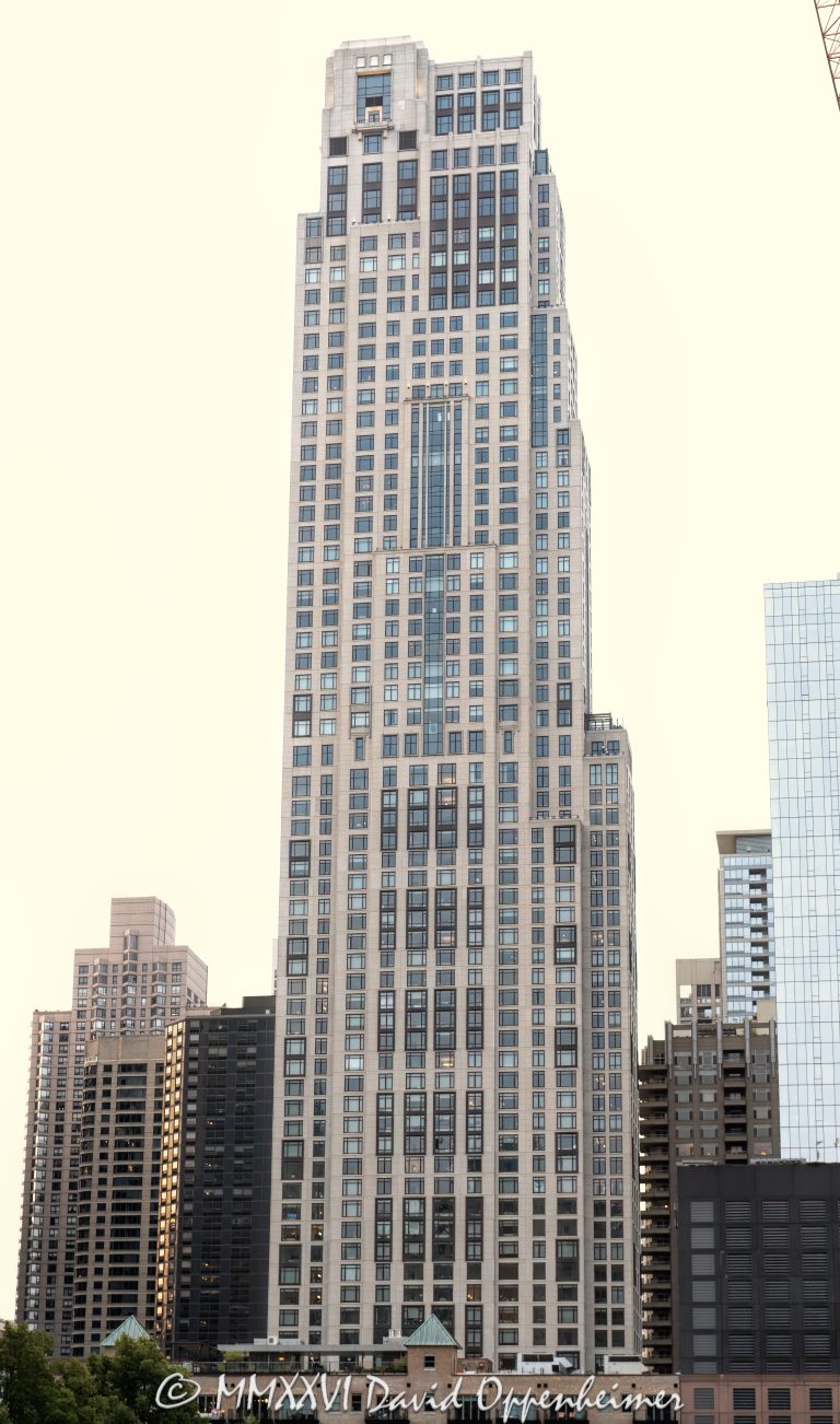 One Bennett Park Apartments rise above Streeterville in Chicago, Illinois. Designed by Robert A.M. Stern Architects for Related Midwest, the Art Deco–inspired residential tower combines luxury rentals and condominiums, with a precast-concrete façade articulated by punched windows, stacked bays, vertical setbacks and an asymmetrical crown – © 2026 David Oppenheimer – Performance Impressions photography archives https://performanceimpressions.com One Bennett Park Apartments, 514 North Peshtigo Court, One Bennett Park, 451 East Grand Avenue, 451 E Grand, One Bennett Park Chicago, One Bennett Park rentals, One Bennett Park condominiums, Streeterville, River East, Chicago, Illinois, Cook County, Near North Side, downtown Chicago, building exterior, facade, exterior, tower exterior, upper tower, residential tower, residential skyscraper, high-rise, skyscraper, Chicago skyscraper, precast concrete facade, precast concrete, limestone base, punched windows, bay windows, stacked bays, metal detailing, vertical setbacks, asymmetrical crown, crowning lantern, Art Deco, Art Deco architecture, Chicago architecture, Streeterville architecture, architecture, tower, building, apartment building, apartments, rental apartments, luxury rentals, luxury apartments, condominiums, luxury condos, residential building, multifamily housing, real estate, luxury real estate, Chicago apartments, Streeterville apartments, Chicago condos, Robert A.M. Stern Architects, RAMSA, Robert A.M. Stern, GREC Architects, GREC Studio, Related Midwest, Related Companies, Related Rentals, Related Management, Lendlease, Lend Lease U.S. Construction, Thornton Tomasetti, structural engineering, Michael Van Valkenburgh Associates, Bennett Park, LEED Silver, sustainable design, USA, United States, 60611, architectural photography, real estate photography, building photography, urban photography, commercial architecture, Licensing, image licensing, commercial imagery, photography licensing, art, print, fine art, commercial photography, David Oppenheimer, vertical, 1-15213827141