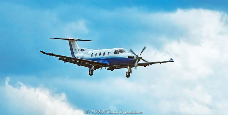 Pilatus PC-12 NG N531AF on landing approach to Asheville Regional Airport near Asheville, North Carolina, shown in flight with landing gear extended against a blue sky and clouds. The single-engine turboprop aircraft is a PC-12/47E associated with the PlaneSense fractional aviation fleet – © 2026 David Oppenheimer – Performance Impressions photography archives https://performanceimpressions.com Pilatus PC-12, Pilatus PC12, PC-12, PC12, Pilatus PC-12 NG, PC-12 NG, Pilatus PC12 NG, PC12 NG, Pilatus PC-12/47E, PC-12/47E, N531AF, N-531AF, 531AF, Pilatus N531AF, N531AF Pilatus, PlaneSense N531AF, Pilatus Aircraft, Pilatus Aircraft Ltd, Pilatus, aircraft, airplane, aeroplane, plane, aviation, aircraft photography, airplane photography, aviation photography, Pilatus photography, PC-12 photography, turboprop, turboprop aircraft, turboprop airplane, single-engine turboprop, single engine, single-engine aircraft, propeller aircraft, propeller airplane, propeller, business aircraft, business aviation, corporate aircraft, corporate aviation, executive aircraft, private aviation, general aviation, GA aircraft, utility aircraft, passenger aircraft, fractional aviation, fractional aircraft, fractional ownership, PlaneSense, PlaneSense PC-12, PlaneSense Pilatus, PlaneSense aircraft, PlaneSense aviation, PlaneSense fleet, PlaneSense Inc, private flight, private flying, landing, aircraft landing, airplane landing, landing approach, final approach, approach, airport approach, aircraft approach, airplane approach, on approach, final, descent, descending, inbound aircraft, arriving aircraft, arrival, aviation arrival, landing gear, landing gear down, gear down, extended landing gear, undercarriage, wheels down, aircraft in flight, airplane in flight, in flight, flying, flight, airborne, aviation action, aviation detail, aircraft close up, airplane close up, close up, close-up, aircraft profile, airplane profile, aircraft exterior, airplane exterior, fuselage, wings, wing, nose, cockpit, windshield, propeller blur, Asheville Regional Airport, Asheville Airport, Asheville Regional, AVL, KAVL, AVL Airport, KAVL Airport, Asheville aviation, Asheville airport approach, Asheville landing, Asheville flight, Asheville, Asheville North Carolina, North Carolina, NC, Western North Carolina, WNC, Blue Ridge, Blue Ridge Mountains, Fletcher, Fletcher North Carolina, Buncombe County, Henderson County, Greater Asheville, Greater Asheville Regional Airport Authority, regional airport, airport, aviation airport, runway approach, runway, Runway 17, Runway 35, Runway 17/35, Class C, Class C airspace, United States, USA, Pilatus Switzerland, Swiss aircraft, Swiss aviation, Stans Switzerland, Switzerland, aircraft manufacturer, aerospace, aerospace engineering, aircraft design, aviation engineering, Pratt & Whitney Canada, Pratt Whitney Canada, Pratt & Whitney, P&W Canada, PWC, PT6A-67P, PT6A, PT6, turboprop engine, aircraft engine, engine, serial 1531, MSN 1531, RIGI Inc, RIGI, Portsmouth New Hampshire, New Hampshire, fractional operator, aviation operator, blue sky, clouds, cloud, sky, atmospheric, painterly, painting-like, painting style, painterly photography, painterly image, painterly effect, rough texture, textured, texture, artistic photography, aviation art, aircraft art, airplane art, Pilatus art, PC-12 art, photorealism, photorealist, photorealistic, photographic art, impressionistic, fine art aviation, fine art photography, aviation fine art, aircraft print, airplane print, aviation print, Pilatus print, PC-12 print, photographic print, fine art print, archival print, gallery print, collector print, wall art, office art, editorial photography, commercial photography, transportation photography, travel photography, licensing, image licensing, commercial imagery, photography licensing, art, print, fine art, commercial photography, David Oppenheimer, Performance Impressions, Performance Impressions photography archives, horizontal, 1-15156784411