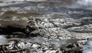 Sierra Nevada Mountains in California with snow and clouds aerial view - © 2024 David Oppenheimer - Performance Impressions aerial photography archives - https://performanceimpressions.com Sierra Nevada Mountains, Sierra Nevada, Sierra Nevada Mountains aerial, Sierra Nevada Mountain Range, Sierras, snow, clouds, snow cover, summer, snowpack, wilderness, nature, mountains, travel, altitude, mountain range, American Cordillera, watershed, Central Valley, California, beauty, elevation, climate, atmosphere, serene, art, aerial, aerial view, aerial photography, aerial photographer, David Oppenheimer, color, horizontal, United States, 1-13985601741,