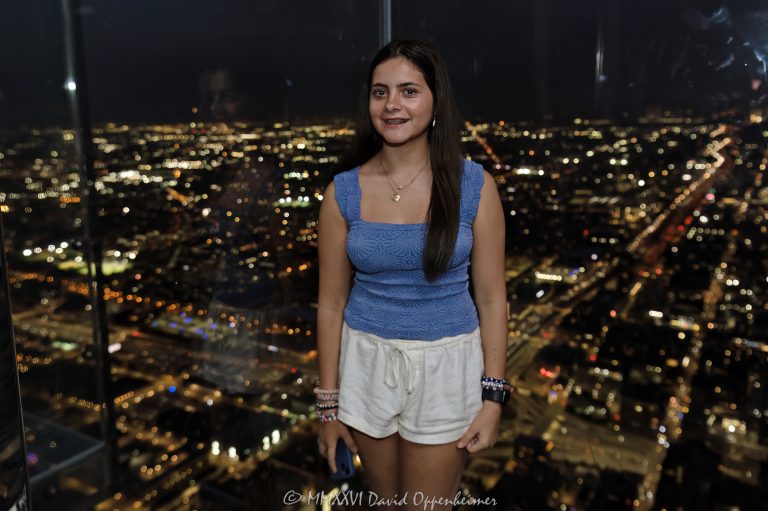 Skydeck Chicago’s Ledge at Willis Tower shows a person inside the glass observation box at night, with transparent floor panels, glass walls, and Chicago city lights beyond the 103rd-floor view. Located at 233 South Wacker Drive, the landmark skyscraper was formerly known as Sears Tower and remains one of Chicago’s best-known observation deck attractions – © 2026 David Oppenheimer – Performance Impressions photography archives https://performanceimpressions.com Skydeck Chicago, Skydeck Chicago Ledge, The Ledge, Willis Tower Skydeck, Willis Tower Ledge, Willis Tower, Sears Tower, former Sears Tower, Sears Tower Chicago, Willis Tower Chicago, 233 S Wacker Drive, 233 South Wacker Drive, 233 S Wacker Dr, South Wacker Drive, Wacker Drive, Chicago Loop, Loop Chicago, downtown Chicago, Chicago Illinois, Chicago IL, 60606, observation deck, observation, deck, glass observation deck, glass ledge, glass box, glass floor, glass walls, glass balcony, transparent floor, transparent walls, glass, floor, walls, night, nighttime, night photography, city lights, Chicago night, Chicago city lights, city view, skyline, skyline view, Chicago skyline, view, lookout, overlook, attraction, experience, vacation, tourism, travel, sightseeing, tourist, tourists, person, silhouette, standing, interior, tower, skyscraper, high rise, building, architecture, architectural photography, Chicago architecture, commercial architecture, modern architecture, Skidmore Owings Merrill, Skidmore Owings & Merrill, SOM, Bruce Graham, Fazlur Rahman Khan, Blackstone, EQ Office, real estate, Chicago real estate, landmark, Chicago landmark, United States, licensing, image licensing, commercial imagery, photography licensing, art, print, fine art, commercial photography, David Oppenheimer, horizontal, 1-15156784411