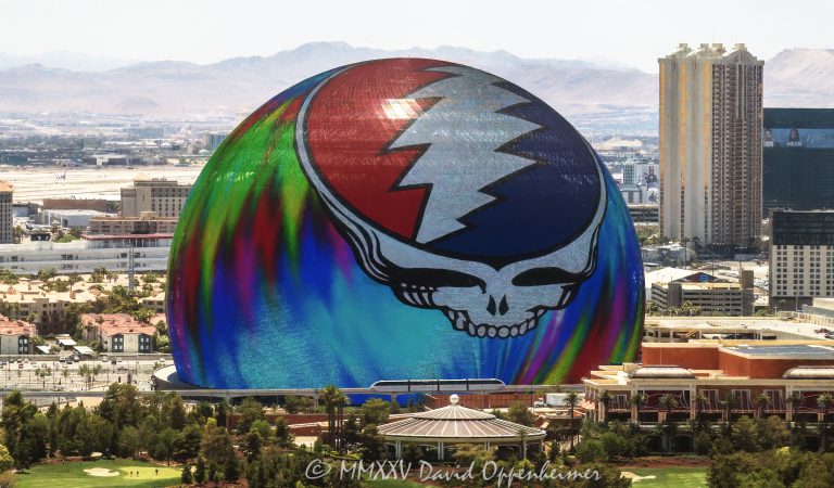 Daytime photograph of Sphere in Las Vegas featuring the illuminated Steal Your Face logo during Dead & Company’s 2024 residency. Despite bright daylight conditions, the vibrant LED display is clearly visible in this aerial view thanks to professional camera exposure and optics - © 2025 David Oppenheimer - Performance Impressions aerial photography archives - https://performanceimpressions.com Sphere, Sphere in Las Vegas, Las Vegas Sphere, MGM Sphere, Sphere at The Venetian, Las Vegas, Steal Your Face, Dead & Company, Grateful Dead, residency, daytime, LED display, facade, building, outside, lights, lighting, 255 Sands Ave, 89169, round, spherical, Sphere Entertainment, Sphere Entertainment Group, Paradise, marketing, advertising, entertainment, media, screen, display, MSG Networks, MSG, Nevada, entrance, architecture, facility, venue, United States, horizontal, color, 1-14977862771