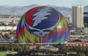 Daytime photograph of Sphere in Las Vegas featuring the illuminated Steal Your Face logo during Dead & Company’s 2024 residency. Despite bright daylight conditions, the vibrant LED display is clearly visible in this aerial view thanks to professional camera exposure and optics - © 2025 David Oppenheimer - Performance Impressions aerial photography archives - https://performanceimpressions.com Sphere, Sphere in Las Vegas, Las Vegas Sphere, MGM Sphere, Sphere at The Venetian, Las Vegas, Steal Your Face, Dead & Company, Grateful Dead, residency, daytime, LED display, facade, building, outside, lights, lighting, 255 Sands Ave, 89169, round, spherical, Sphere Entertainment, Sphere Entertainment Group, Paradise, marketing, advertising, entertainment, media, screen, display, MSG Networks, MSG, Nevada, entrance, architecture, facility, venue, United States, horizontal, color, 1-14977862771