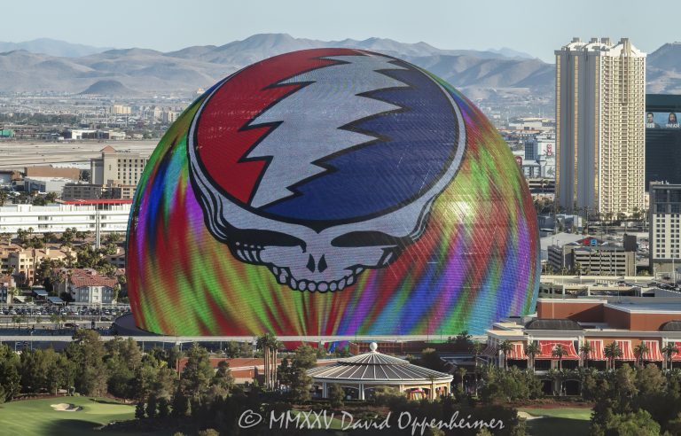 Daytime photograph of Sphere in Las Vegas featuring the illuminated Steal Your Face logo during Dead & Company’s 2024 residency. Despite bright daylight conditions, the vibrant LED display is clearly visible in this aerial view thanks to professional camera exposure and optics - © 2025 David Oppenheimer - Performance Impressions aerial photography archives - https://performanceimpressions.com Sphere, Sphere in Las Vegas, Las Vegas Sphere, MGM Sphere, Sphere at The Venetian, Las Vegas, Steal Your Face, Dead & Company, Grateful Dead, residency, daytime, LED display, facade, building, outside, lights, lighting, 255 Sands Ave, 89169, round, spherical, Sphere Entertainment, Sphere Entertainment Group, Paradise, marketing, advertising, entertainment, media, screen, display, MSG Networks, MSG, Nevada, entrance, architecture, facility, venue, United States, horizontal, color, 1-14977862771