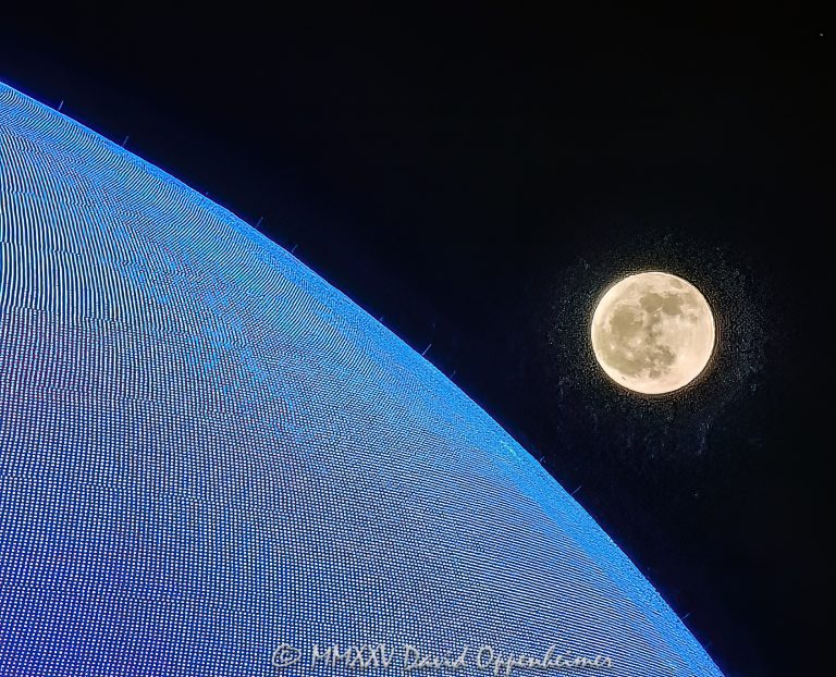 Sphere Las Vegas at night illuminated in blue with the full moon rising in the background. This close up photograph highlights the scale and futuristic LED exterior of the iconic venue on the Las Vegas Strip – © 2025 David Oppenheimer – Performance Impressions Travel Photography Archives – https://performanceimpressions.com Sphere, Sphere in Las Vegas, Las Vegas Sphere, MGM Sphere, Sphere at The Venetian, Sphere Entertainment, Sphere Entertainment Group, Las Vegas, Paradise, Nevada, LED display, LED pixels, lighting, night, nighttime, architecture, architture, exterior, facade, building, venue, entertainment, design, round, spherical, illuminated, full moon, moon, skyline, landmark, Nevada, futuristic, future, space, advertising, marketing, media, display, screen, MSG Networks, MSG, 255 Sands Ave, 89169, resort, casino, Las Vegas Strip, United States, horizontal, color, photography, fine art photography, Performance Impressions, 1-14993092111