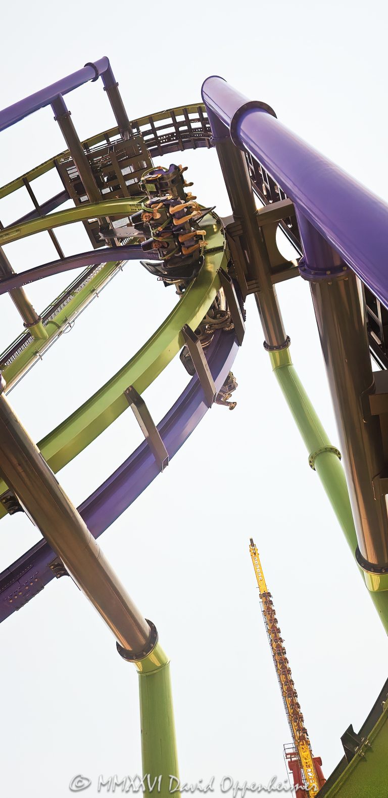 THE JOKER Free-Fly Coaster at Six Flags Great America near Chicago in Gurnee, Illinois, shown in close-up with The Joker character theming in the foreground and a coaster car flipping overhead on the attraction’s green-and-purple track. The DC Universe thrill ride is an S&S Worldwide 4D Free Spin coaster using exposed wing seating and magnetic spin-control technology to rotate riders head-over-heels – © 2026 David Oppenheimer – Performance Impressions photography archives https://performanceimpressions.com THE JOKER Free-Fly Coaster, THE JOKER Free Fly Coaster, Joker Free-Fly Coaster, Joker Free Fly Coaster, THE JOKER, The Joker, Joker, Joker coaster, Joker roller coaster, Joker ride, Six Flags Joker, Joker Six Flags, Six Flags Great America Joker, Great America Joker, Joker Chicago, Joker Illinois, DC Joker, DC Comics Joker, Joker character, Joker figure, Joker theming, Joker theme, Joker display, Joker face, Joker sign, Joker signage, supervillain, DC supervillain, villain, comic villain, comic book villain, comic character, DC Comics, DC, DC Universe, Six Flags DC Universe, DC Universe Six Flags, Great America DC Universe, DC Universe Chicago, DC Universe Illinois, roller coaster, roller coasters, coaster, coasters, steel coaster, steel roller coaster, 4D coaster, 4D roller coaster, 4D Free Spin, 4D Free Spin coaster, S&S 4D Free Spin, free spin, free-spin coaster, free fly, free-fly coaster, freestyle coaster, thrill coaster, thrill ride, thrill rides, amusement ride, theme park ride, ride, rides, coaster car, coaster vehicle, ride vehicle, winged vehicle, winged seats, wing seating, exposed seating, spinning coaster, spinning vehicle, flipping coaster, flipping riders, head-over-heels, head over heels, flips, flipping, spin, spinning, rotation, rotating seats, inversions, inversion, weightlessness, free fall, freefall, 90-degree hill, vertical lift, coaster track, roller coaster track, track, stacked track, overhead track, overhead coaster, coaster overhead, riders overhead, green track, purple track, green and purple, amusement park, theme park, amusement parks, theme parks, amusement park attraction, theme park attraction, coaster attraction, park attraction, attraction, attractions, themed attraction, themed entertainment, themed design, comic-book theme, comic theme, S&S Worldwide, S&S, S and S Worldwide, S&S Worldwide Inc, S&S coaster, S&S roller coaster, coaster manufacturer, ride manufacturer, amusement manufacturer, ride engineering, coaster engineering, engineering, engineer, amusement engineering, magnetic spin control, magnetic spin, magnetic technology, spin control, magnetic braking, eddy current, eddy current brake, ride technology, coaster technology, Todd Snyder, Mike Worley, Alan Schilke, coaster designer, ride designer, amusement design, Bleck & Bleck Architects, Bleck and Bleck Architects, Bleck Architects, Bleck & Bleck, theme park architect, theme park architecture, architect, architects, architecture, architectural design, theme park design, ride integration, attraction integration, theme integration, concept integration, land planning, marquee design, lighting design, ride structures, structural design, control systems, control integration, electrical integration, Yankee Harbor, Six Flags Yankee Harbor, DC Universe, Six Flags Great America, Six Flags Great America Chicago, Great America Chicago, Great America Illinois, Six Flags Chicago, Six Flags Illinois, Six Flags, Great America, Gurnee, Gurnee Illinois, Gurnee IL, Illinois, Lake County, Lake County Illinois, northern Illinois, Chicagoland, Chicago area, Chicago, Chicago Illinois, Chicago theme park, Chicago amusement park, Chicago attraction, Chicago attractions, Chicago tourism, Chicago travel, Visit Chicago, Illinois attraction, Illinois attractions, Illinois tourism, Illinois travel, Visit Illinois, Midwest, Midwest attraction, Midwest amusement park, Midwest theme park, Great America Parkway, 1 Great America Parkway, Grand Avenue, Route 132, Interstate 94, I-94, 60031, United States, USA, Six Flags Entertainment Corporation, Six Flags Entertainment, Six Flags company, Six Flags stock, FUN, NYSE FUN, Sansei Technologies, Sansei Group, Sansei, TSE 6357, 6357, amusement park photography, theme park photography, roller coaster photography, coaster photography, thrill ride photography, action photography, Joker photography, DC photography, entertainment photography, travel photography, tourism photography, editorial photography, commercial photography, fine art photography, amusement park art, theme park art, roller coaster art, Joker art, DC art, Six Flags art, Great America art, Chicago art, roller coaster print, Joker print, Six Flags print, Great America print, photographic print, fine art print, archival print, gallery print, collector print, wall art, licensing, image licensing, commercial imagery, photography licensing, art, print, fine art, commercial photography, David Oppenheimer, Performance Impressions, Performance Impressions photography archives, 1-15156784411