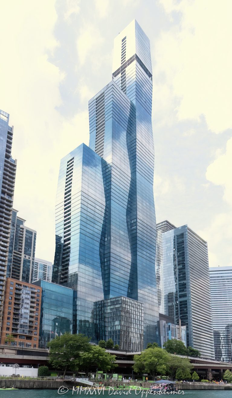 The St. Regis Chicago at 401 East Wacker Drive rises above the Chicago River and Riverwalk, with the river, landscaped riverfront, and Riverwalk Playground visible in the foreground. Designed by Studio Gang Architects and developed by Magellan Development Group, the 101-story mixed-use hotel and condominium tower was formerly known as Wanda Vista Tower and includes The Residences at The St. Regis Chicago – © 2026 David Oppenheimer – Performance Impressions photography archives https://performanceimpressions.com The St. Regis Chicago, St. Regis Chicago, The St Regis Chicago, St Regis Chicago, The Residences at The St. Regis Chicago, St. Regis Residences, St Regis Residences, St. Regis Hotels & Resorts, St Regis Hotels, Marriott, Marriott International, Marriott Bonvoy, 401 E Wacker Drive, 401 East Wacker Drive, 401 E Wacker Dr, 363 E Wacker Drive, 363 East Wacker Drive, East Wacker Drive, Wacker Drive, Wanda Vista Tower, Vista Tower, Vista Tower Chicago, Lakeshore East, Lakeshore East Chicago, downtown Chicago, Chicago Illinois, Chicago IL, 60601, Chicago River, river, riverfront, waterfront, Chicago riverfront, Chicago waterfront, Chicago Riverwalk, Riverwalk, Riverwalk Playground, facade, building exterior, exterior, glass facade, blue green glass, reflective glass, tower, hotel tower, residential tower, condo tower, condominium tower, skyscraper, supertall, high rise, mixed use tower, mixed use building, hotel, luxury hotel, five star hotel, St. Regis hotel, condominium, condominiums, luxury condos, luxury residences, residential real estate, Chicago real estate, luxury real estate, riverfront real estate, waterfront real estate, architecture, architectural photography, Chicago architecture, contemporary architecture, residential architecture, hotel architecture, Studio Gang Architects, Studio Gang, Jeanne Gang, Magellan Development Group, bKL Architecture, Gensler, OLIN, Marriott hotel, luxury hospitality, hospitality, travel, tourism, Illinois architecture, United States, licensing, image licensing, commercial imagery, photography licensing, art, print, fine art, commercial photography, David Oppenheimer, vertical, 1-15156784411