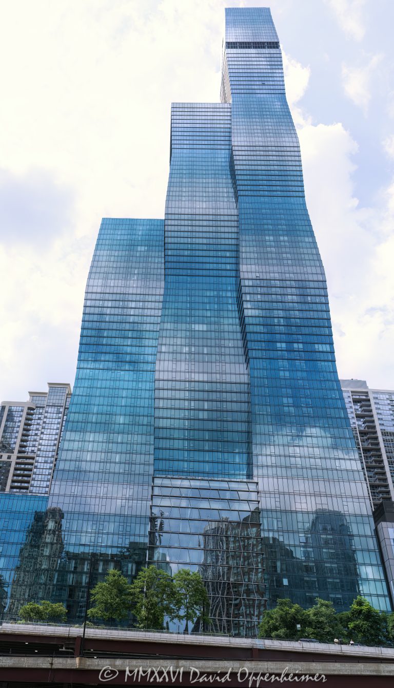 The St. Regis Chicago at 401 East Wacker Drive rises above the Chicago River and Riverwalk. Designed by Studio Gang Architects and developed by Magellan Development Group, the 101-story mixed-use hotel and condominium tower was formerly known as Wanda Vista Tower and includes The Residences at The St. Regis Chicago – © 2026 David Oppenheimer – Performance Impressions photography archives https://performanceimpressions.com The St. Regis Chicago, St. Regis Chicago, The St Regis Chicago, St Regis Chicago, The Residences at The St. Regis Chicago, St. Regis Residences, St Regis Residences, St. Regis Hotels & Resorts, St Regis Hotels, Marriott, Marriott International, Marriott Bonvoy, 401 E Wacker Drive, 401 East Wacker Drive, 401 E Wacker Dr, 363 E Wacker Drive, 363 East Wacker Drive, East Wacker Drive, Wacker Drive, Wanda Vista Tower, Vista Tower, Vista Tower Chicago, Lakeshore East, Lakeshore East Chicago, downtown Chicago, Chicago Illinois, Chicago IL, 60601, Chicago River, river, riverfront, waterfront, Chicago riverfront, Chicago waterfront, Chicago Riverwalk, Riverwalk, Riverwalk Playground, facade, building exterior, exterior, glass facade, blue green glass, reflective glass, tower, hotel tower, residential tower, condo tower, condominium tower, skyscraper, supertall, high rise, mixed use tower, mixed use building, hotel, luxury hotel, five star hotel, St. Regis hotel, condominium, condominiums, luxury condos, luxury residences, residential real estate, Chicago real estate, luxury real estate, riverfront real estate, waterfront real estate, architecture, architectural photography, Chicago architecture, contemporary architecture, residential architecture, hotel architecture, Studio Gang Architects, Studio Gang, Jeanne Gang, Magellan Development Group, bKL Architecture, Gensler, OLIN, Marriott hotel, luxury hospitality, hospitality, travel, tourism, Illinois architecture, United States, licensing, image licensing, commercial imagery, photography licensing, art, print, fine art, commercial photography, David Oppenheimer, vertical, 1-15156784411