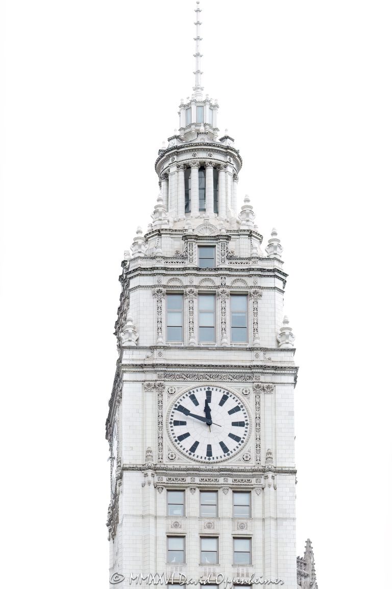 Wrigley Building clock tower rises above North Michigan Avenue along the Chicago River, featuring its white glazed terra cotta facade and prominent four-faced clock, a defining element of this historic Chicago landmark designed by Graham, Anderson, Probst & White for William Wrigley Jr. – © 2026 David Oppenheimer – Performance Impressions photography archives https://performanceimpressions.com Wrigley Building, Wrigley Building Chicago, Wrigley Building clock tower, 400 North Michigan Avenue, 410 North Michigan Avenue, 400-410 North Michigan Avenue, North Michigan Avenue, Michigan Avenue, Chicago River, riverfront, downtown Chicago, Chicago, Chicago Illinois, Chicago IL, Illinois, 60611, clock tower, clock, clock face, tower detail, facade, building exterior, exterior, white terra cotta, glazed terra cotta, terra cotta facade, white facade, ornate facade, historic facade, landmark building, Chicago Landmark, historic building, tower, north tower, south tower, skyscraper, high rise, office building, commercial building, Wrigley Company, Wm Wrigley Jr Company, William Wrigley Jr, architecture, architectural photography, Chicago architecture, historic architecture, riverfront architecture, commercial architecture, Spanish Colonial Revival, French Renaissance Revival, Graham Anderson Probst & White, Graham Anderson Probst White, Alfred P Shaw, Chicago history, Illinois architecture, United States, licensing, image licensing, commercial imagery, photography licensing, art, print, fine art, commercial photography, David Oppenheimer, 1-15213827141