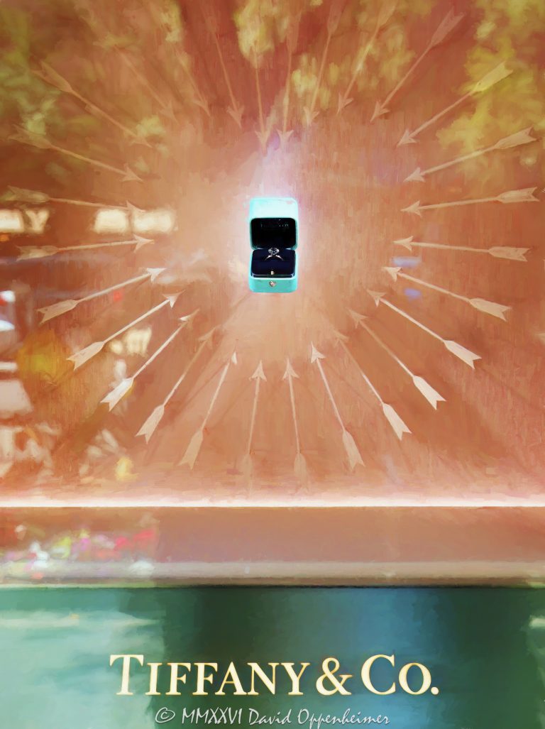 Tiffany & Co. window display at 730 North Michigan Avenue in Chicago centers on a depiction of a diamond ring in an open black velvet-lined Tiffany Blue box, appearing to float within a heart formed by glowing arrows in orange, red, and yellow light. Reflections in the glass and Tiffany & Co. signage beneath the display create a surreal fine-art composition along the Magnificent Mile in Chicago, Illinois – © 2026 David Oppenheimer – Performance Impressions photography archives https://performanceimpressions.com Tiffany & Co., Tiffany and Co, Tiffany & Co. Chicago, Tiffany Chicago, Tiffany Chicago store, Tiffany Michigan Avenue, Tiffany jewelry store, Tiffany storefront, Tiffany window display, Tiffany diamond ring, Tiffany engagement ring, Tiffany Blue, Tiffany blue box, Tiffany ring box, Tiffany signage, diamond ring, engagement ring, diamond jewelry, fine jewelry, luxury jewelry, jewelry box, ring box, open ring box, black velvet, velvet lining, heart of light, arrow heart, heart shape, heart display, illuminated arrows, glowing arrows, floating ring box, hovering box, surreal display, abstract display, window display, store window, retail window, storefront display, jewelry display, luxury display, visual merchandising, window dressing, retail design, display design, product display, luxury retail, luxury boutique, jewelry store, storefront, glass window, brand signage, luxury branding, reflections, window reflections, glass reflections, layered reflections, urban reflections, abstract reflections, reflection photography, illuminated display, glowing window, warm light, fiery light, orange, red, yellow, pastel colors, saturated color, vivid color, colorful, surreal, surrealism, surreal photography, surreal art, dreamlike, abstract, abstraction, abstract photography, abstract art, conceptual photography, conceptual art, fine art photography, fine art photograph, art photography, contemporary photography, creative photography, urban fine art, photorealism, photo realism, photorealistic, painterly, painterly photography, visual illusion, optical illusion, luxury still life, still life photography, retail photography, storefront photography, window display photography, commercial art, luxury art, jewelry art, diamond art, diamond ring art, Tiffany art, Tiffany window art, Tiffany photography, Tiffany print, Tiffany poster, Tiffany wall art, Chicago art, Chicago photography, Chicago wall art, Michigan Avenue art, Magnificent Mile art, surreal wall art, abstract wall art, luxury wall art, fine art print, photographic print, archival print, gallery print, collector print, collectible art, art poster, fine art poster, wall art, wall decor, luxury decor, home decor, office decor, interior design, statement art, art collector, photography collector, Tiffany collector, love, romance, engagement, proposal, iconic blue box, blue box, 730 North Michigan Avenue, 730 N Michigan Avenue, North Michigan Avenue, Michigan Avenue, Magnificent Mile, Mag Mile, Near North Side, downtown Chicago, Chicago shopping, Magnificent Mile shopping, Chicago, Chicago Illinois, Chicago IL, Illinois, 60611, LVMH, LVMH Group, LVMH Tiffany, Tiffany LVMH, Tiffany parent company, LVMH Moët Hennessy Louis Vuitton, LVMH Moet Hennessy Louis Vuitton, LVMH luxury group, luxury conglomerate, luxury goods, watches and jewelry, LVMH stock, LVMH MC, LVMH ticker MC, Euronext Paris MC, LVMUY, LVMUY stock, OTC LVMUY, United States, licensing, image licensing, commercial imagery, photography licensing, art, print, fine art, commercial photography, Performance Impressions, David Oppenheimer, vertical, 1-15213827141