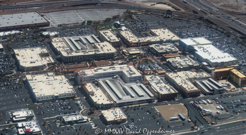 Town Square Las Vegas Aerial View Town Square Las Vegas outdoor shopping center at 6605 Las Vegas Blvd South in Las Vegas, Nevada aerial view – © 2025 David Oppenheimer – Performance Impressions aerial photography archives – https://performanceimpressions.com Town Square, Town Square Las Vegas, Town Square Las Vegas aerial, Town Square Park, 6605 Las Vegas Blvd S, Las Vegas, 89119, Clark County, Nevada, United States, outdoor shopping center, retail dining entertainment, public park, central lawn, green space, water features, fountains, park, shopping, retail, outdoor, open-air, Whole Foods, Old Navy, H&M, TJ Max, Element Hotel, Saks Off 5th, splash pad, children’s park, playground, shade structures, palm trees, pedestrian streets, AMC Town Square 18, plazas, event space, lawn events, family friendly, restaurants, bars, movie theater, parking lots, ring roads, Las Vegas Boulevard, I-15, 215 Beltway, south Strip, urban park, landscape design, mixed-use, architecture, aerial, aerial view, horizontal, color, daytime, sunny, desert setting, Southwest, tourism, destination, travel, cityscape, metropolitan, commercial district, shopping precinct, entertainment district, pedestrian friendly, walkways, streetscape, The Guest House Las Vegas, open space, xeriscape, maintenance, management office, concierge, Town Square events, 702-269-5001, USA. horizontal, color, 1-14993092111