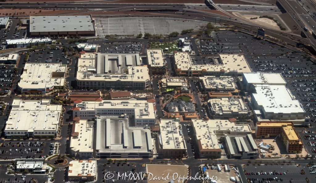 Town Square Las Vegas Aerial View Town Square Las Vegas outdoor shopping center at 6605 Las Vegas Blvd South in Las Vegas, Nevada aerial view – © 2025 David Oppenheimer – Performance Impressions aerial photography archives – https://performanceimpressions.com Town Square, Town Square Las Vegas, Town Square Las Vegas aerial, Town Square Park, 6605 Las Vegas Blvd S, Las Vegas, 89119, Clark County, Nevada, United States, outdoor shopping center, retail dining entertainment, public park, central lawn, green space, water features, fountains, park, shopping, retail, outdoor, open-air, Whole Foods, Old Navy, H&M, TJ Max, Element Hotel, Saks Off 5th, splash pad, children’s park, playground, shade structures, palm trees, pedestrian streets, AMC Town Square 18, plazas, event space, lawn events, family friendly, restaurants, bars, movie theater, parking lots, ring roads, Las Vegas Boulevard, I-15, 215 Beltway, south Strip, urban park, landscape design, mixed-use, architecture, aerial, aerial view, horizontal, color, daytime, sunny, desert setting, Southwest, tourism, destination, travel, cityscape, metropolitan, commercial district, shopping precinct, entertainment district, pedestrian friendly, walkways, streetscape, The Guest House Las Vegas, open space, xeriscape, maintenance, management office, concierge, Town Square events, 702-269-5001, USA. horizontal, color, 1-14993092111