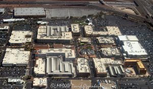 Town Square Las Vegas outdoor shopping center at 6605 Las Vegas Blvd South in Las Vegas, Nevada aerial view – © 2025 David Oppenheimer – Performance Impressions aerial photography archives – https://performanceimpressions.com Town Square, Town Square Las Vegas, Town Square Las Vegas aerial, Town Square Park, 6605 Las Vegas Blvd S, Las Vegas, 89119, Clark County, Nevada, United States, outdoor shopping center, retail dining entertainment, public park, central lawn, green space, water features, fountains, park, shopping, retail, outdoor, open-air, Whole Foods, Old Navy, H&M, TJ Max, Element Hotel, Saks Off 5th, splash pad, children’s park, playground, shade structures, palm trees, pedestrian streets, AMC Town Square 18, plazas, event space, lawn events, family friendly, restaurants, bars, movie theater, parking lots, ring roads, Las Vegas Boulevard, I-15, 215 Beltway, south Strip, urban park, landscape design, mixed-use, architecture, aerial, aerial view, horizontal, color, daytime, sunny, desert setting, Southwest, tourism, destination, travel, cityscape, metropolitan, commercial district, shopping precinct, entertainment district, pedestrian friendly, walkways, streetscape, The Guest House Las Vegas, open space, xeriscape, maintenance, management office, concierge, Town Square events, 702-269-5001, USA. horizontal, color, 1-14993092111