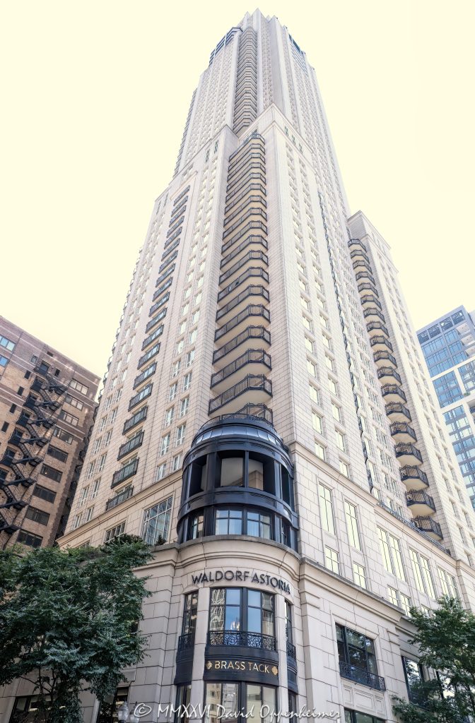 Waldorf Astoria Chicago at 11 East Walton Street rises above the Gold Coast in a dramatic street-level perspective, framing the full 60-story hotel-and-residence tower from Brass Tack signage near the base to its upper floors. Designed by Lucien Lagrange Architects, the Parisian-inspired luxury property stands near Rush Street and one block from the Magnificent Mile in Chicago, Illinois – © 2026 David Oppenheimer – Performance Impressions photography archives https://performanceimpressions.com Waldorf Astoria Chicago, Waldorf Astoria Chicago Hotel, Waldorf Astoria, Waldorf Astoria Hotels & Resorts, 11 East Walton Street, 11 E Walton St, East Walton Street, Walton Street, Gold Coast, Gold Coast Chicago, Chicago Gold Coast, Rush Street, Rush Street Chicago, Magnificent Mile, Mag Mile, Near North Side, downtown Chicago, Chicago, Chicago Illinois, Chicago IL, Illinois, 60611, facade, building exterior, exterior, hotel exterior, hotel facade, full tower, upper tower, tower, hotel tower, skyscraper, high rise, luxury hotel, Chicago hotel, Gold Coast hotel, Chicago luxury hotel, luxury Chicago hotel, luxury hospitality, five star luxury, hotel and residences, private residences, luxury residences, condominiums, luxury condos, residential tower, mixed use, mixed-use tower, looking up, upward perspective, street level, vertical perspective, limestone facade, stone facade, architectural detail, textured facade, mansard roof, French inspired, Parisian inspired, chateau style, French architecture, hotel architecture, luxury architecture, hospitality architecture, Chicago architecture, architectural photography, Brass Tack, Brass Tack Chicago, Brass Tack restaurant, Brass Tack signage, restaurant, dining, Waldorf Astoria Spa, Waldorf Astoria Spa & Health Club, spa, luxury spa, spa hotel, Chicago spa, wellness, Hilton, Hilton Hotels, Hilton Worldwide, Hilton Worldwide Holdings, Hilton Honors, Hilton luxury, Hilton luxury hotel, HLT, NYSE HLT, The Elysian, Elysian Hotel, Elysian Hotel Chicago, Elysian Chicago, Elysian Hotel and Private Residences, former Elysian, Lucien Lagrange, Lucien Lagrange Architects, Elysian Development, David Pisor, Halvorson and Partners, hospitality, tourism, travel, luxury travel, Chicago tourism, Chicago hospitality, hotel photography, exterior photography, commercial architecture, real estate, luxury real estate, Chicago real estate, residential real estate, United States, licensing, image licensing, commercial imagery, photography licensing, art, print, fine art, commercial photography, David Oppenheimer, vertical, 1-15213827141