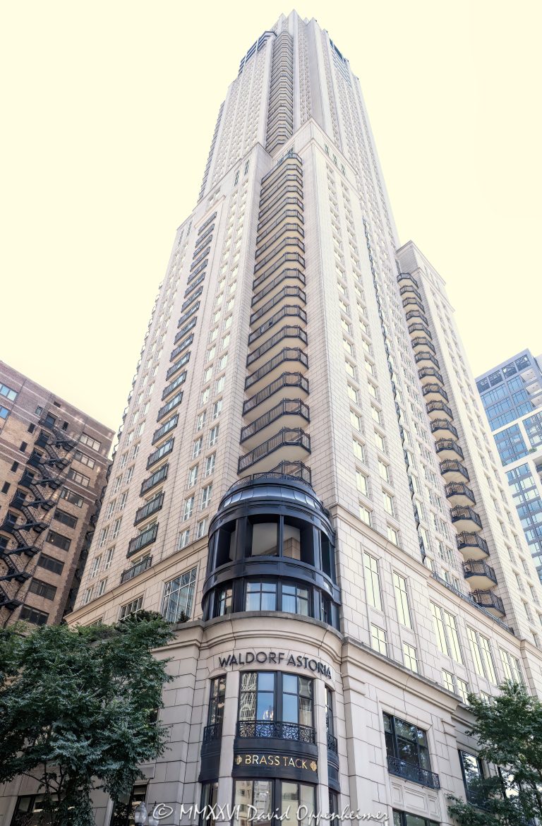 Waldorf Astoria Chicago at 11 East Walton Street rises above the Gold Coast in a dramatic street-level perspective, framing the full 60-story hotel-and-residence tower from Brass Tack signage near the base to its upper floors. Designed by Lucien Lagrange Architects, the Parisian-inspired luxury property stands near Rush Street and one block from the Magnificent Mile in Chicago, Illinois – © 2026 David Oppenheimer – Performance Impressions photography archives https://performanceimpressions.com Waldorf Astoria Chicago, Waldorf Astoria Chicago Hotel, Waldorf Astoria, Waldorf Astoria Hotels & Resorts, 11 East Walton Street, 11 E Walton St, East Walton Street, Walton Street, Gold Coast, Gold Coast Chicago, Chicago Gold Coast, Rush Street, Rush Street Chicago, Magnificent Mile, Mag Mile, Near North Side, downtown Chicago, Chicago, Chicago Illinois, Chicago IL, Illinois, 60611, facade, building exterior, exterior, hotel exterior, hotel facade, full tower, upper tower, tower, hotel tower, skyscraper, high rise, luxury hotel, Chicago hotel, Gold Coast hotel, Chicago luxury hotel, luxury Chicago hotel, luxury hospitality, five star luxury, hotel and residences, private residences, luxury residences, condominiums, luxury condos, residential tower, mixed use, mixed-use tower, looking up, upward perspective, street level, vertical perspective, limestone facade, stone facade, architectural detail, textured facade, mansard roof, French inspired, Parisian inspired, chateau style, French architecture, hotel architecture, luxury architecture, hospitality architecture, Chicago architecture, architectural photography, Brass Tack, Brass Tack Chicago, Brass Tack restaurant, Brass Tack signage, restaurant, dining, Waldorf Astoria Spa, Waldorf Astoria Spa & Health Club, spa, luxury spa, spa hotel, Chicago spa, wellness, Hilton, Hilton Hotels, Hilton Worldwide, Hilton Worldwide Holdings, Hilton Honors, Hilton luxury, Hilton luxury hotel, HLT, NYSE HLT, The Elysian, Elysian Hotel, Elysian Hotel Chicago, Elysian Chicago, Elysian Hotel and Private Residences, former Elysian, Lucien Lagrange, Lucien Lagrange Architects, Elysian Development, David Pisor, Halvorson and Partners, hospitality, tourism, travel, luxury travel, Chicago tourism, Chicago hospitality, hotel photography, exterior photography, commercial architecture, real estate, luxury real estate, Chicago real estate, residential real estate, United States, licensing, image licensing, commercial imagery, photography licensing, art, print, fine art, commercial photography, David Oppenheimer, vertical, 1-15213827141
