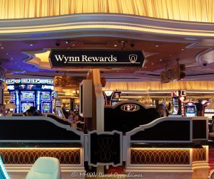 Wynn Rewards desk on the casino floor at Wynn Las Vegas Resort and Casino in Las Vegas, Nevada – © 2025 David Oppenheimer – Performance Impressions casino photography archives – https://performanceimpressions.com Wynn Rewards, Wynn Rewards desk, signage, staff, rewards, slot machines, slots, Wynn Casino, casino, gaming, play, betting, odds, win, gambling, wager, bet, luck, gamble, 3355 S Las Vegas Blvd, 89109, Wynn, players club, club, Encore, Encore Las Vegas, Encore Resort, Encore Casino, Encore Vegas, Encore at Wynn, Wynn Las Vegas, Wynn Vegas, Wynn Resort, Wynn Resorts, 3131 Las Vegas Blvd S, 89109, hotel, resort, WYNN, WYNN stock, five star, five-star, luxury, Las Vegas, Vegas, Las Vegas Strip, casino floor, entertainment, luxury gaming, Nevada casino, vacation, art, casino art, concierge, desk, card, Nevada, Nevada photography, lighting, colorful, United States, vertical, color, 1-14993092111