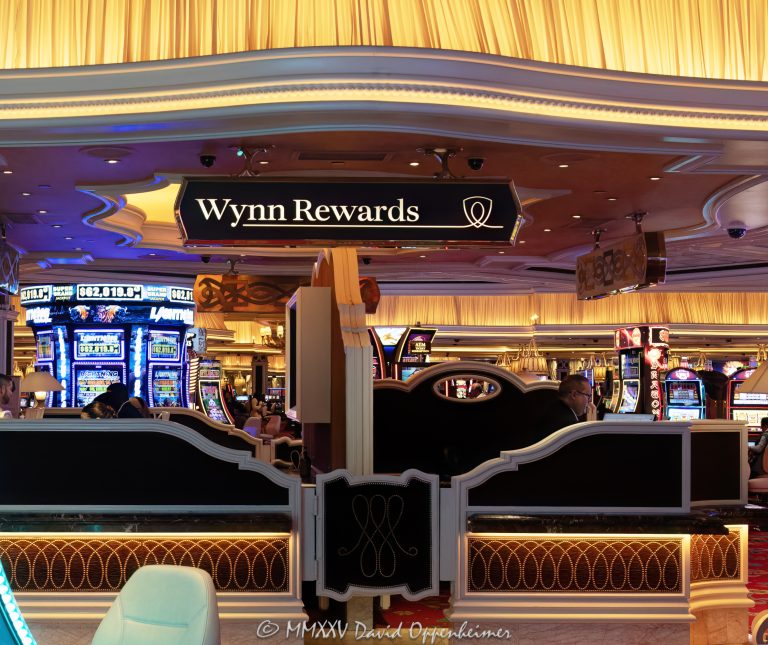 Wynn Rewards desk on the casino floor at Wynn Las Vegas Resort and Casino in Las Vegas, Nevada – © 2025 David Oppenheimer – Performance Impressions casino photography archives – https://performanceimpressions.com Wynn Rewards, Wynn Rewards desk, signage, staff, rewards, slot machines, slots, Wynn Casino, casino, gaming, play, betting, odds, win, gambling, wager, bet, luck, gamble, 3355 S Las Vegas Blvd, 89109, Wynn, players club, club, Encore, Encore Las Vegas, Encore Resort, Encore Casino, Encore Vegas, Encore at Wynn, Wynn Las Vegas, Wynn Vegas, Wynn Resort, Wynn Resorts, 3131 Las Vegas Blvd S, 89109, hotel, resort, WYNN, WYNN stock, five star, five-star, luxury, Las Vegas, Vegas, Las Vegas Strip, casino floor, entertainment, luxury gaming, Nevada casino, vacation, art, casino art, concierge, desk, card, Nevada, Nevada photography, lighting, colorful, United States, vertical, color, 1-14993092111