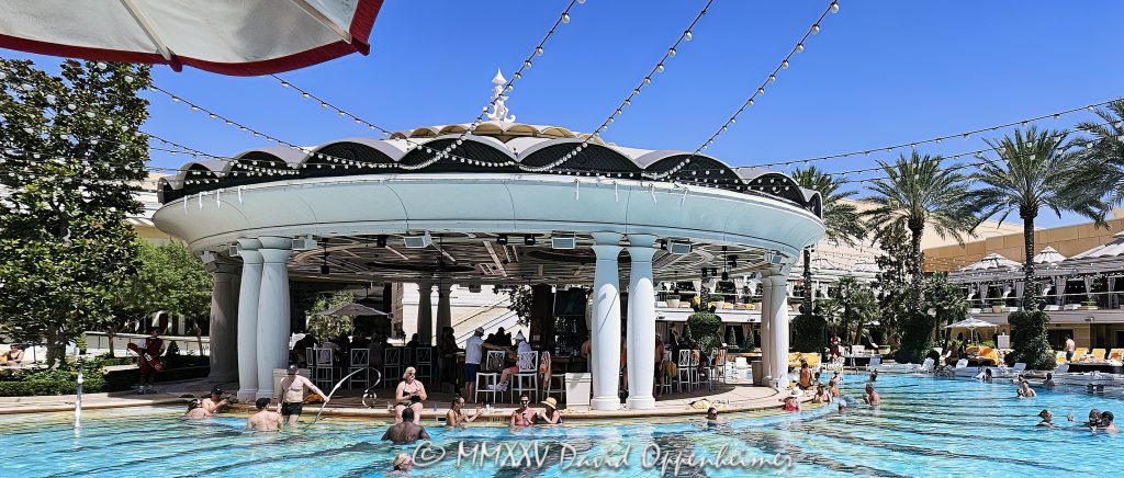 Poolside Bar at The Pool at Wynn Las Vegas Resort and Casino Poolside bar at The Pool at the Wynn Las Vegas Resort and Casino in Las Vegas, Nevada – © 2025 David Oppenheimer – Performance Impressions Travel Photography Archives – https://performanceimpressions.com The Pool, Wynn Pool, pool, swimming, swimming pool, resort pool, poolside, pool deck, poolside bar, bar, cocktails, drinks, mixology, lounge, cabanas, daybeds, umbrellas, palm trees, leisure, relaxation, summer, vacation, entertainment, XS, XS Night Swim, Wynn XS, XS pool party, XS Las Vegas, daytime, resort, casino, hotel, luxury resort, luxury hotel, Las Vegas casino, Las Vegas resort, hospitality, five star, fine art photography, resort photography, travel photography, resort design, architecture, landscape architecture, design, modern, contemporary, luxury lifestyle, reflections, water reflections, turquoise, blue, elegant, opulent, Wynn Las Vegas, Wynn, Wynn Resort, Wynn Casino, Wynn Resorts, Encore Las Vegas, Encore Resort, Encore Casino, Encore at Wynn, Las Vegas, Vegas, Nevada, Las Vegas Strip, 3131 Las Vegas Blvd S, 89109, United States, USA, horizontal, color, 1-14993092112